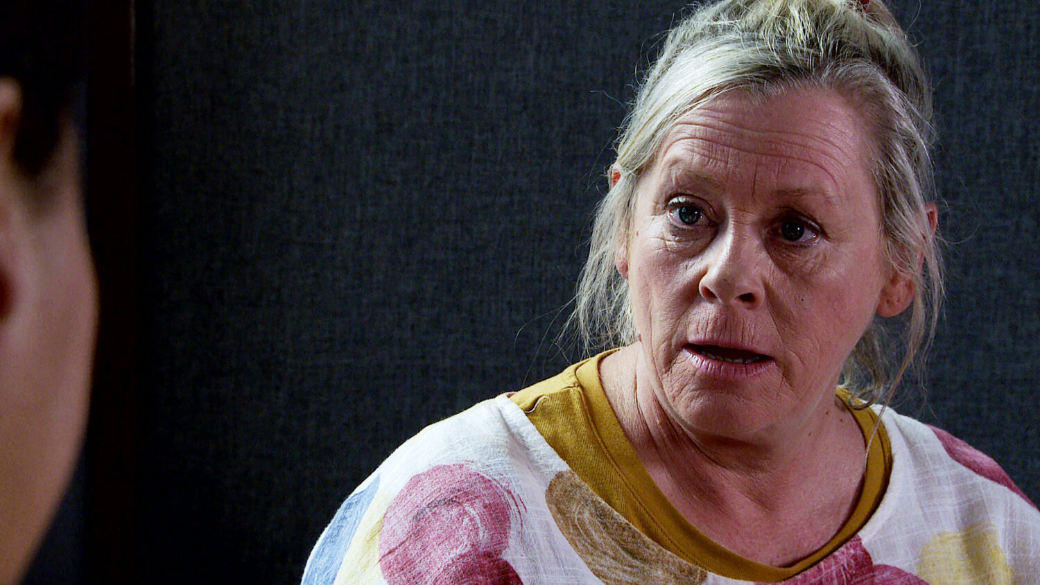 Bernie in the police station, looks serious Corrie