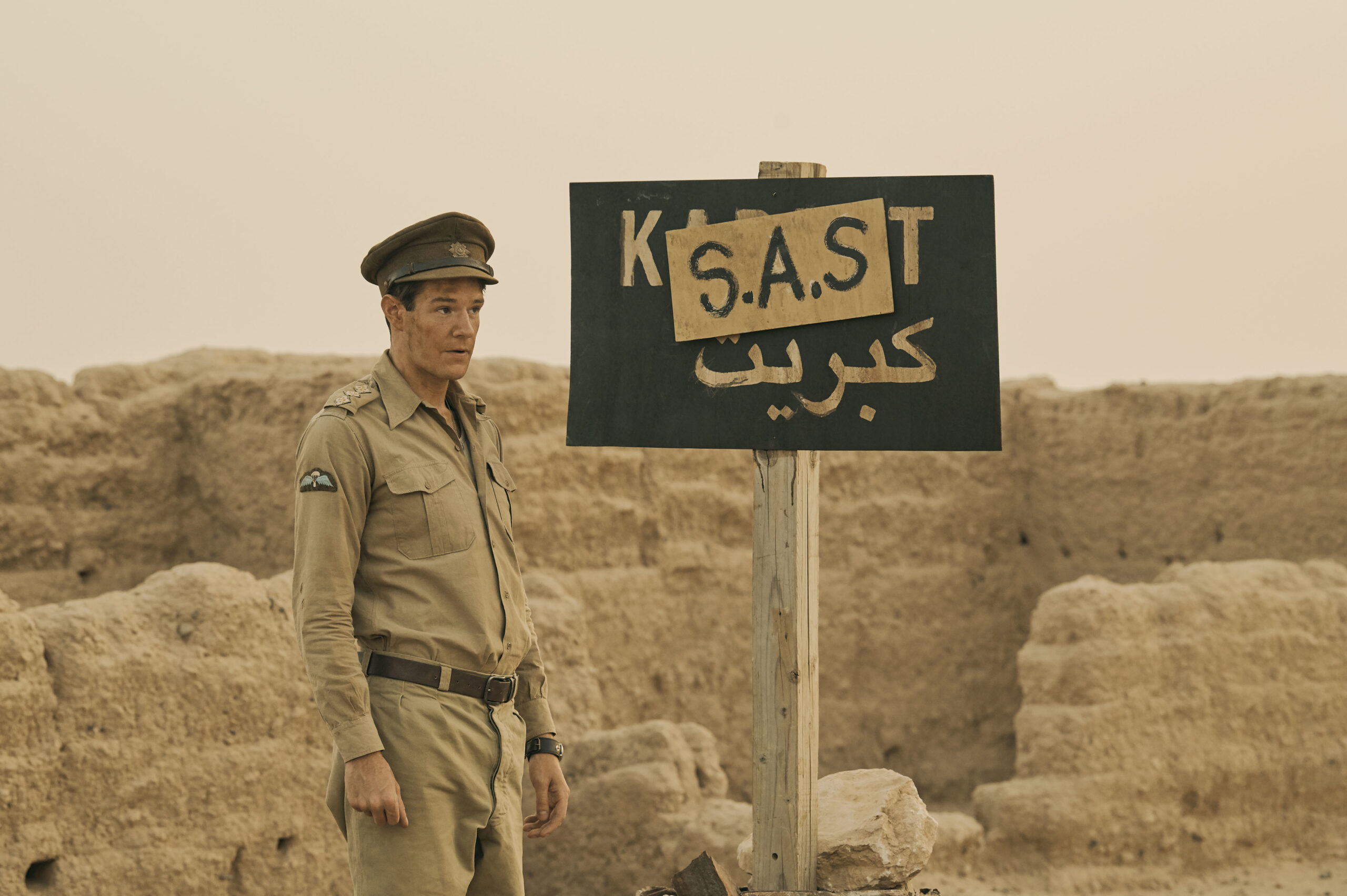 Connor Swindells standing next to an SAS sign