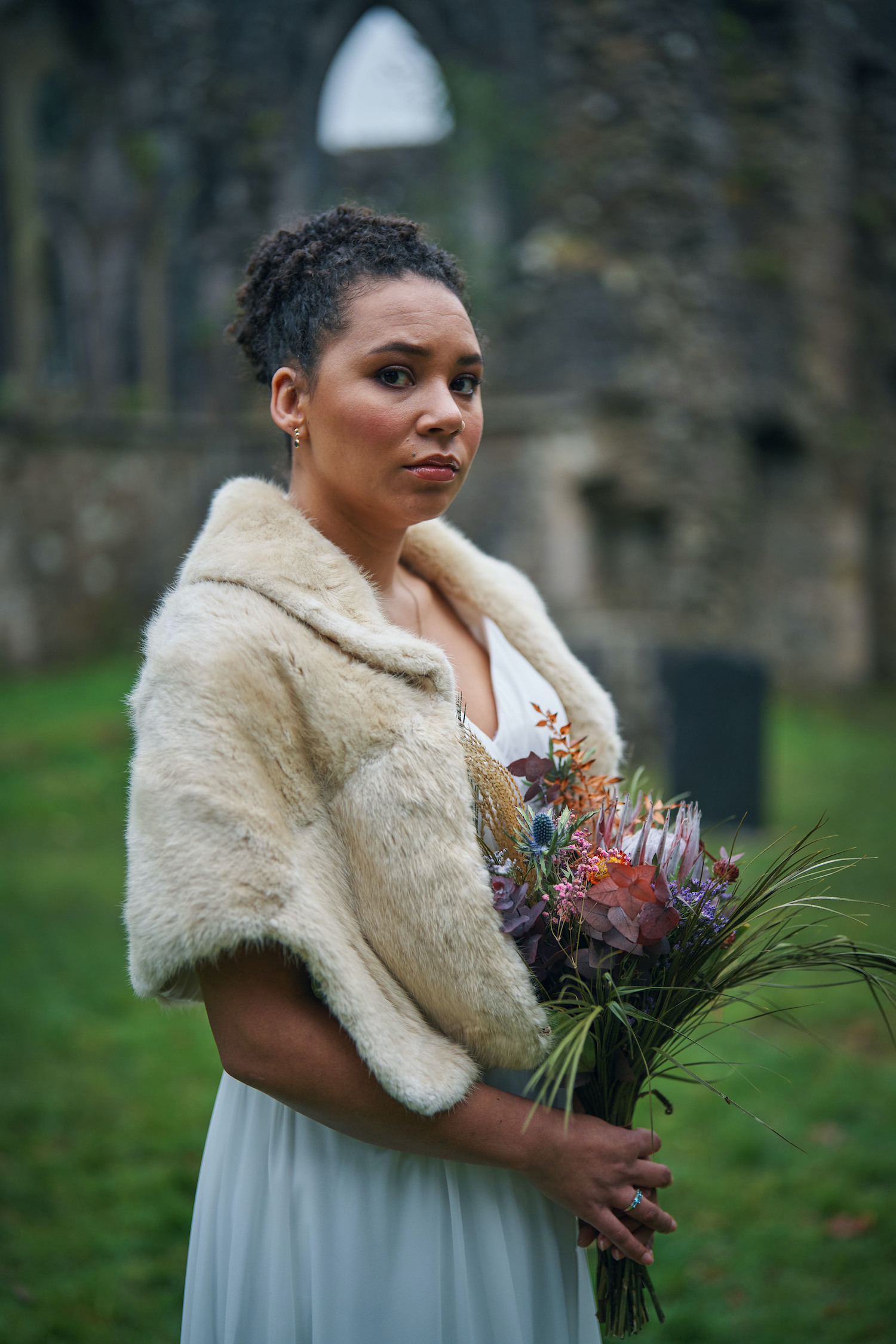Megan (Mali Ann Rees) from The Pact 2 in a wedding dress holding her bouquet looking serious
