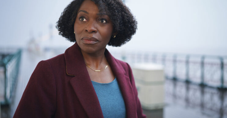 Rakie Ayola standing on a pier looking worried