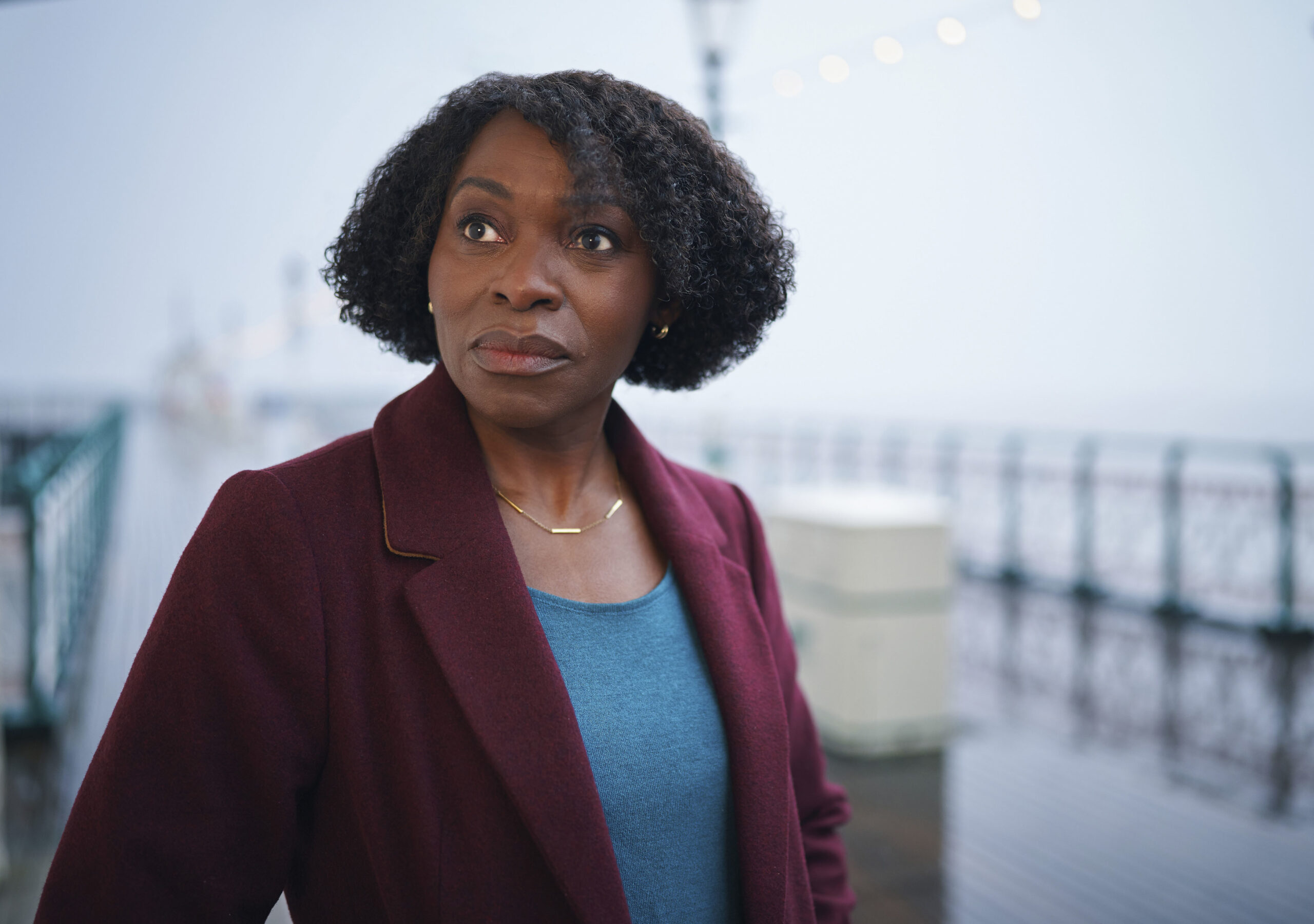 Rakie Ayola standing on a pier looking worried