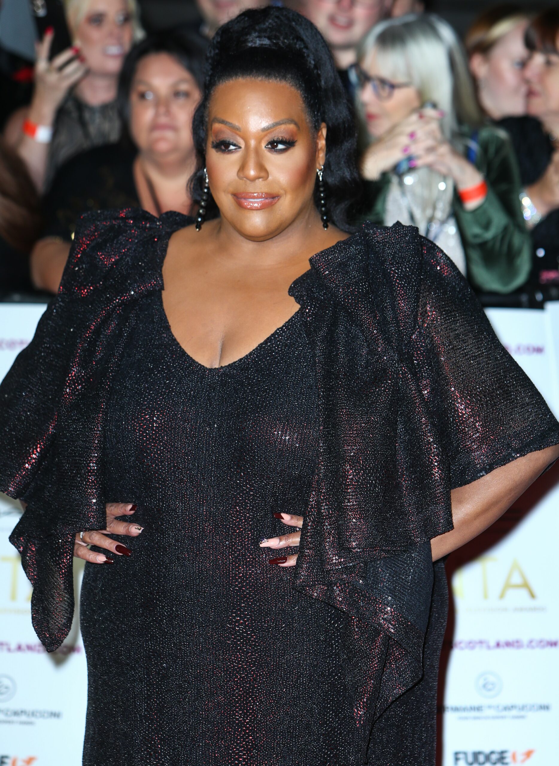 Alison Hammond with her hands on her hips in black dress at NTAs
