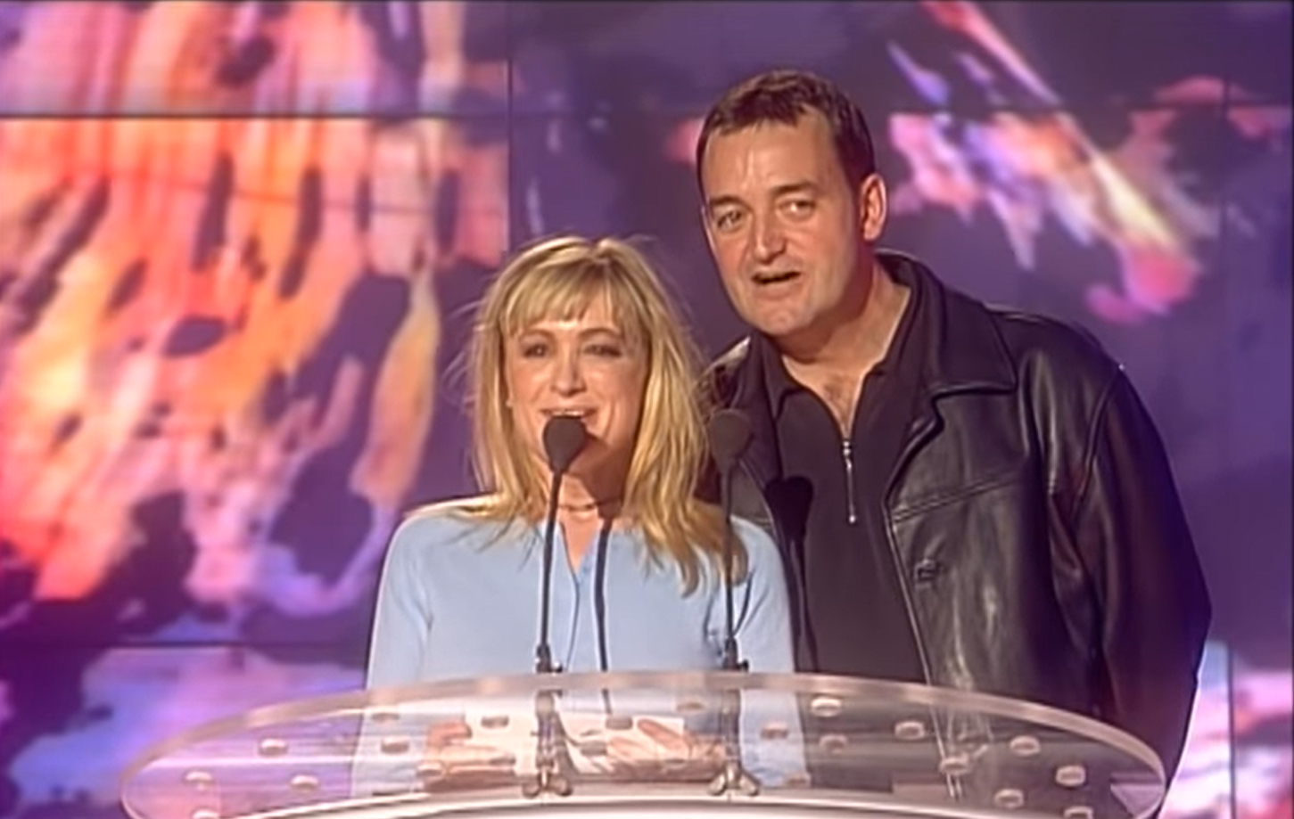 Caroline Ahern and Craig Cash announce an award at the Brits, they stand on a stage with a mic and smiles