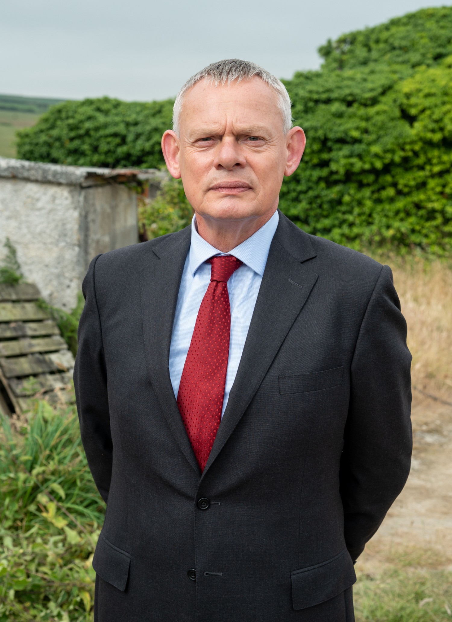 Martin Clunes wearing a red tie in Doc Martin