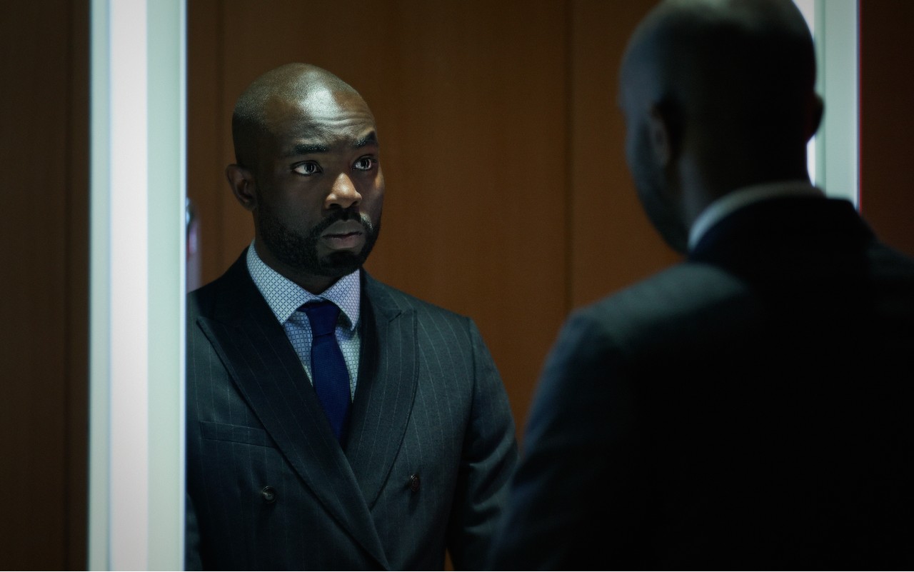 Paapa Essiedu as Alexander Dumani in Gangs of London, he looks into a mirror with a stressed expression