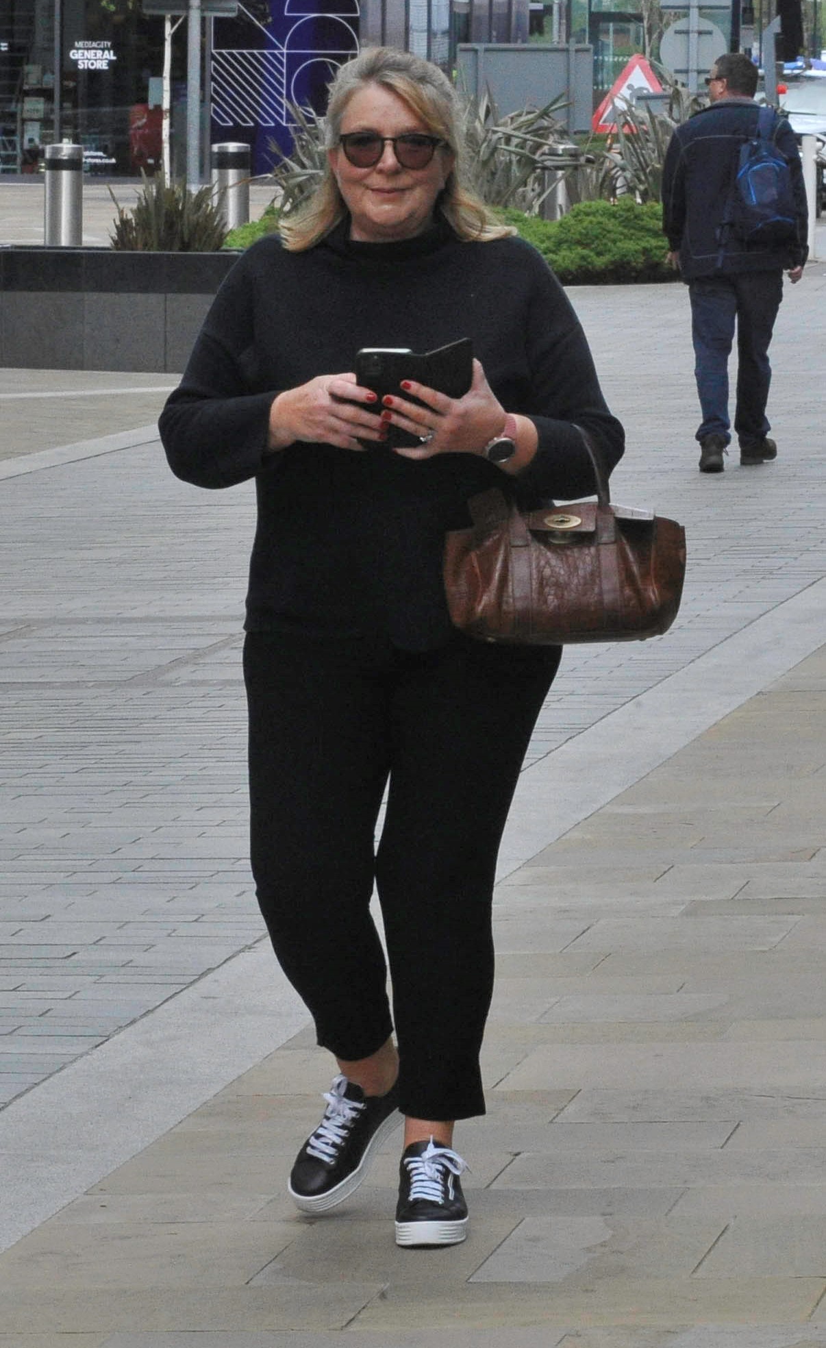 Fern Britton wearing sunglasses and on her phone outside studios