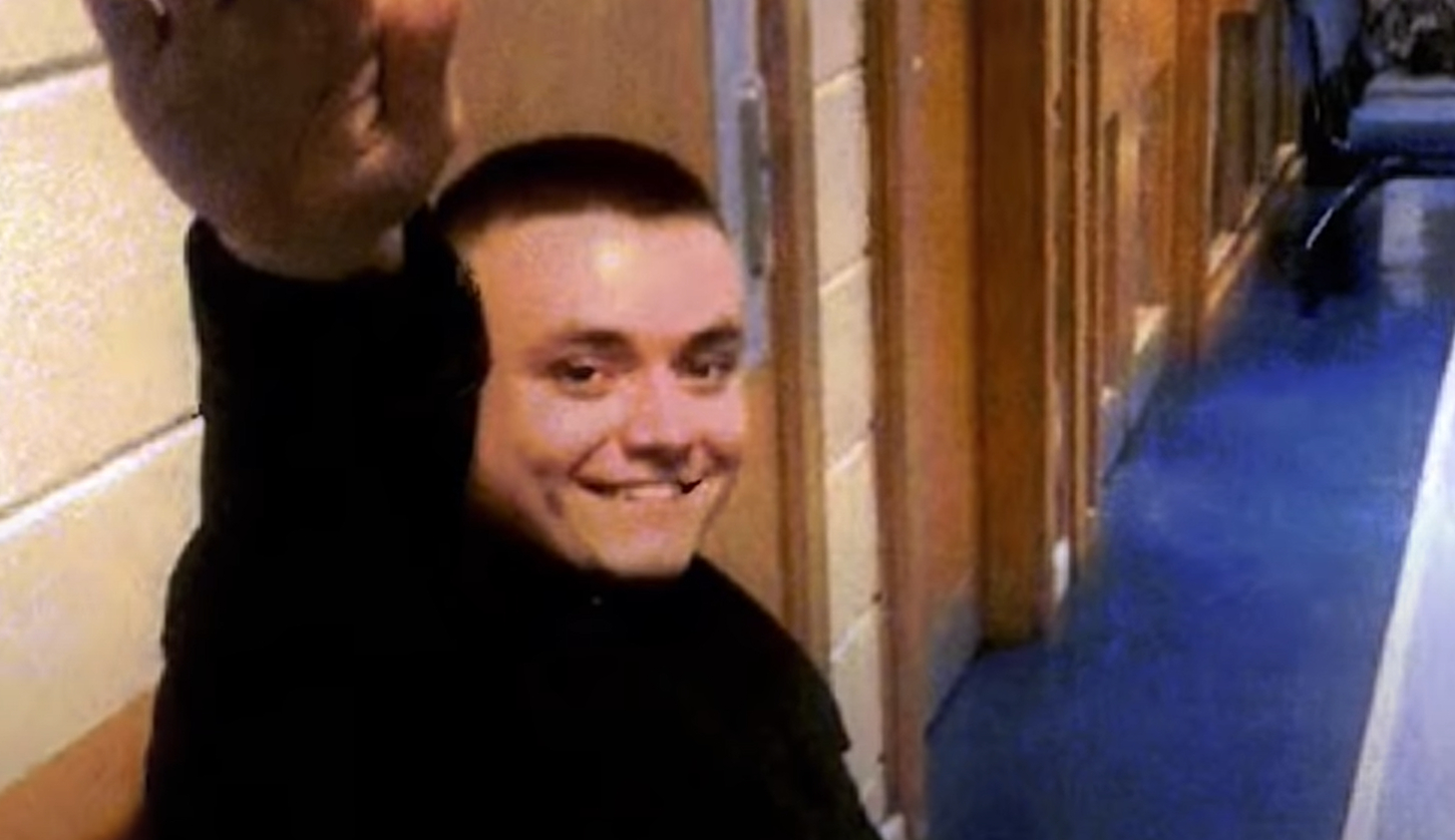 Jack Renshaw smiles and gives a Nazi salute in a corridor