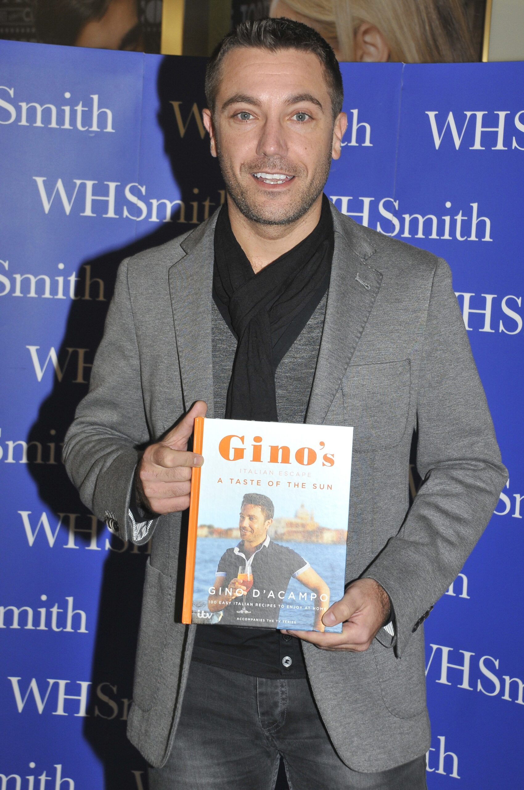Gino D'Acampo on the red carpet holding his cook book