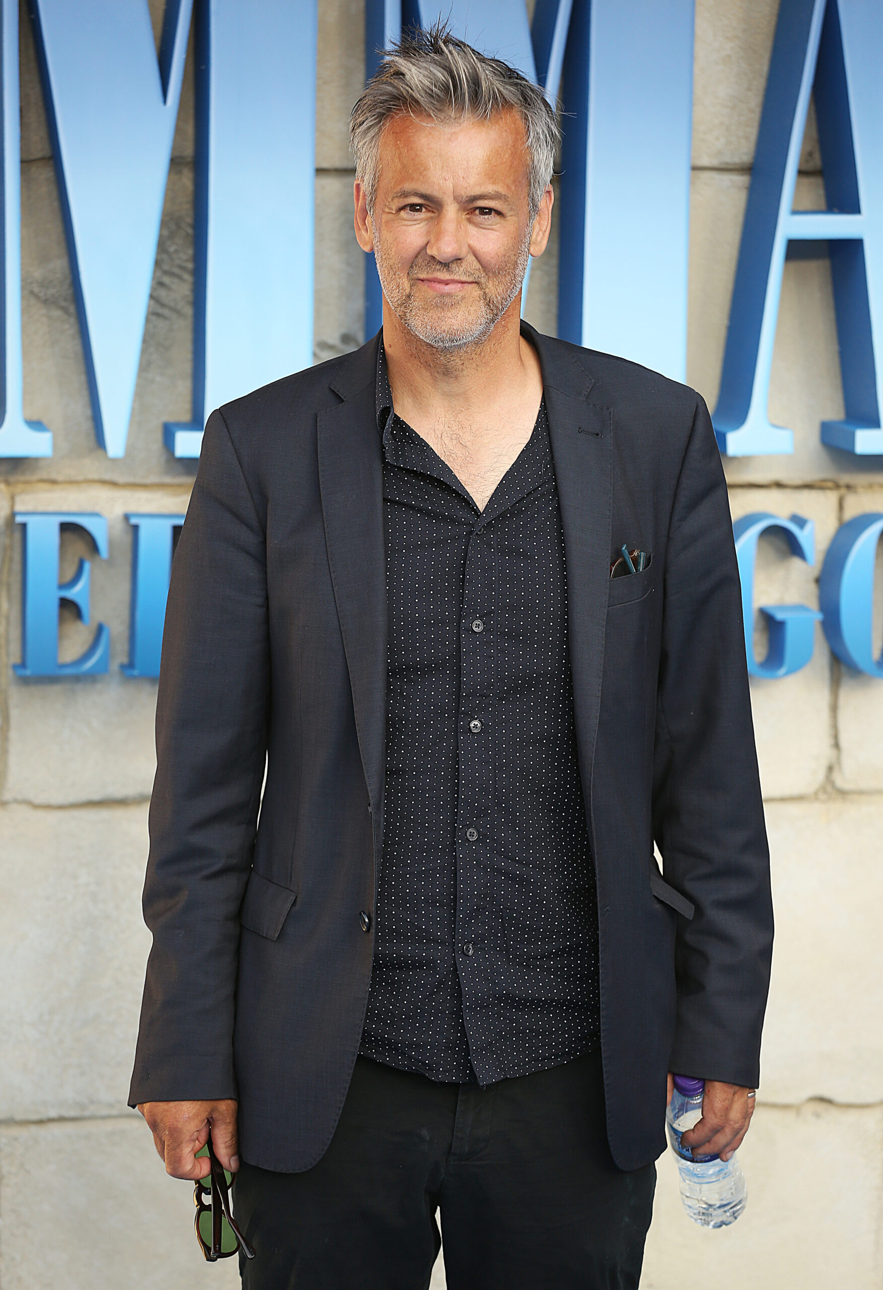 Ruper Graves wearing a black suit 