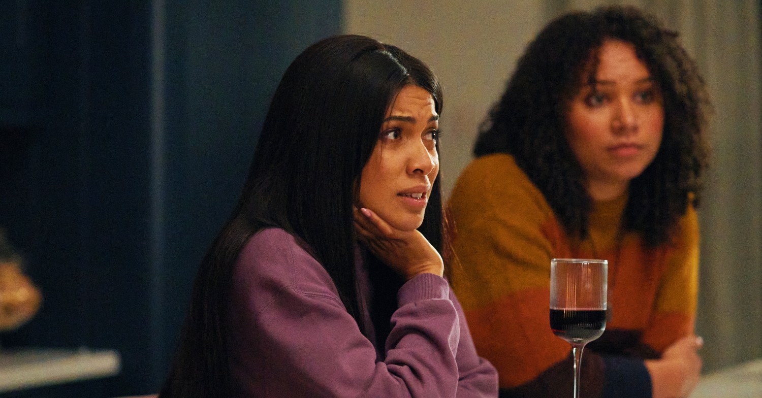 Sam (Rebekah Murrell) sit next to megan with a glass of wine in her kitchen looking worried