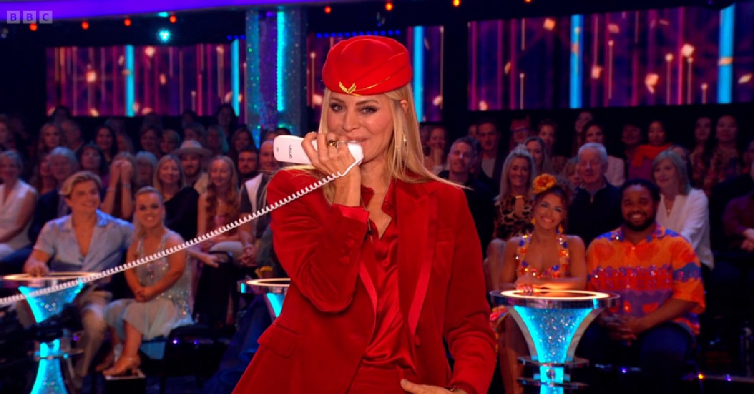 Tess Daly speaking into a phone on Strictly