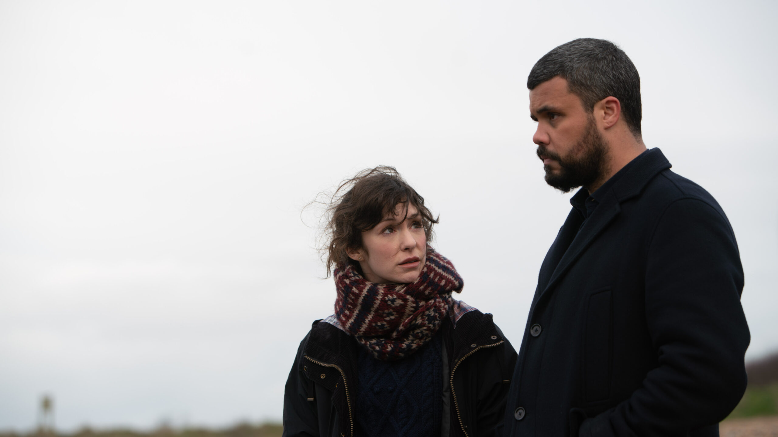 Sophia Del Pizzo as Nikki (left) and Howard Charles as Mike McGuire (right) in Whitstable Pearl, she looks up at him with a worried expression as they stand outside