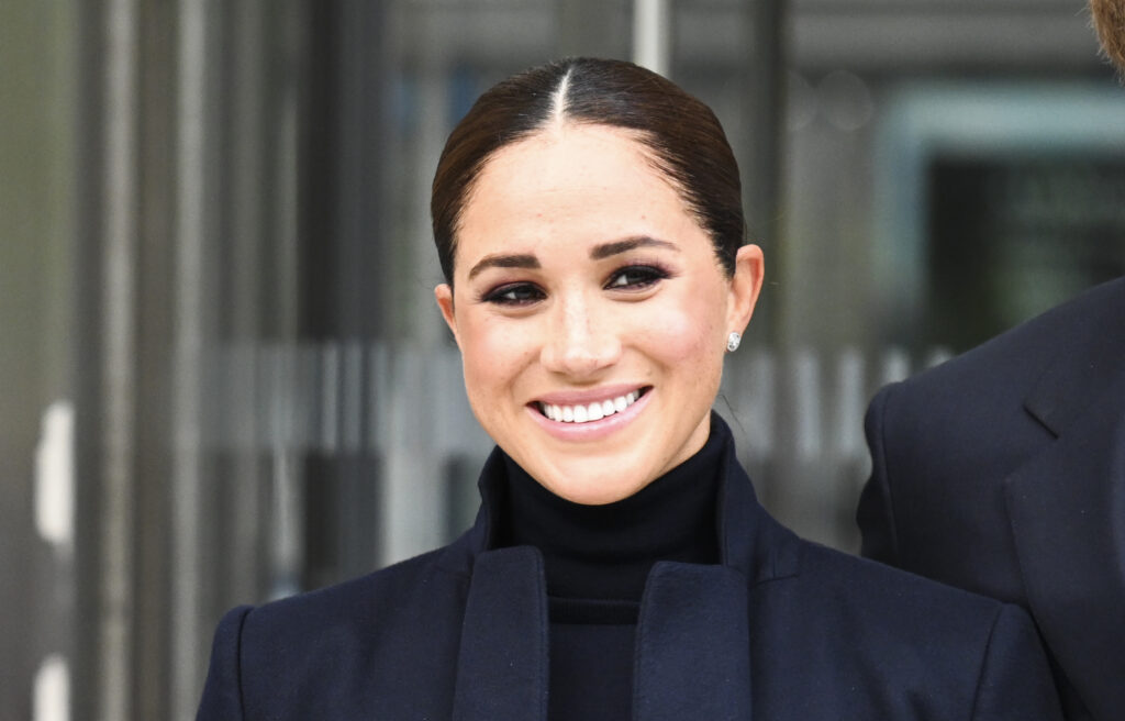 Meghan Markle wears a black turtle neck and coat