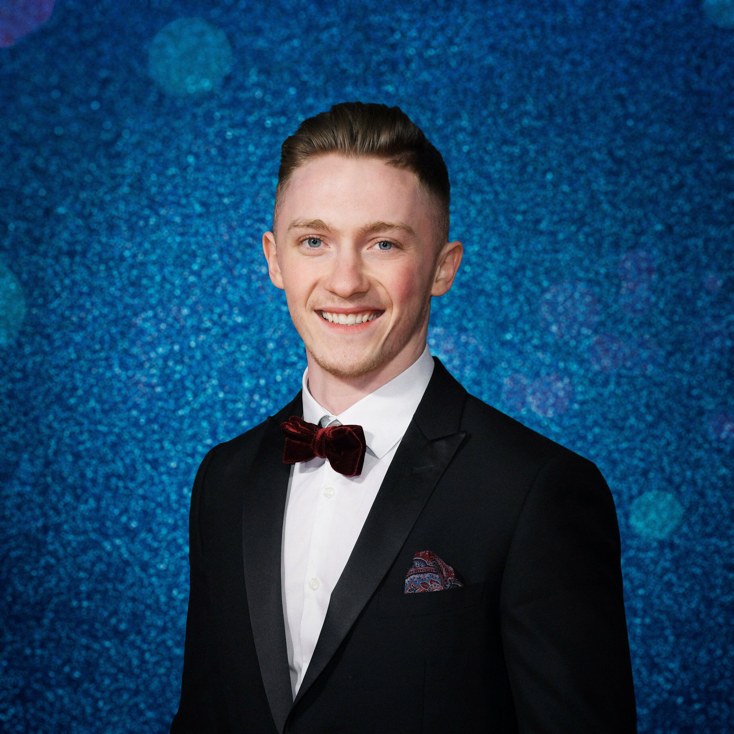Nile in front of a blue glitter background for Dancing On Ice