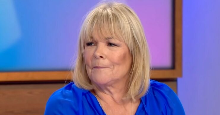 Linda Robson smirking in blue top on Loose Women