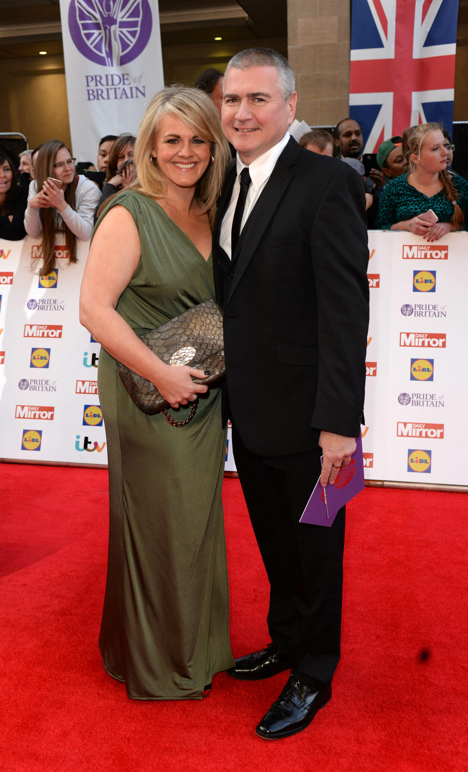 Sally Lindsay and Steve White pose and smile on a red carpet