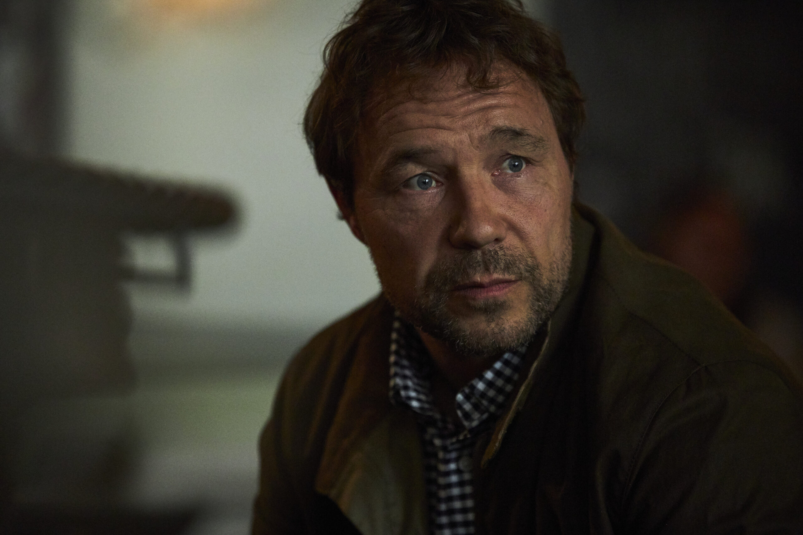 Stephen Graham as Matthew Collins in The Walk-In, he looks to his right with a small frown in the hope not hate office