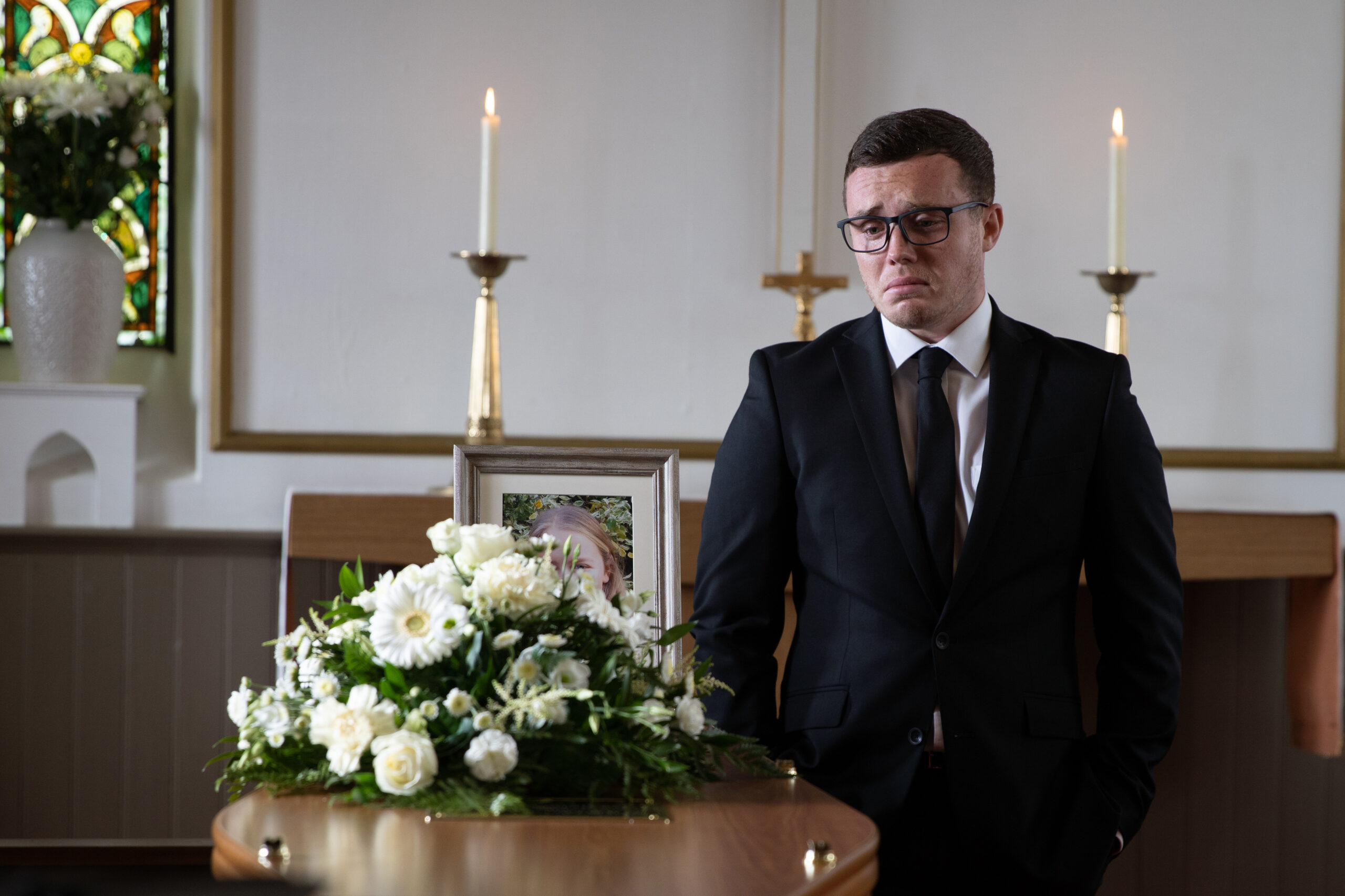 Vinny crying standing over Liv's coffin in Emmerdale
