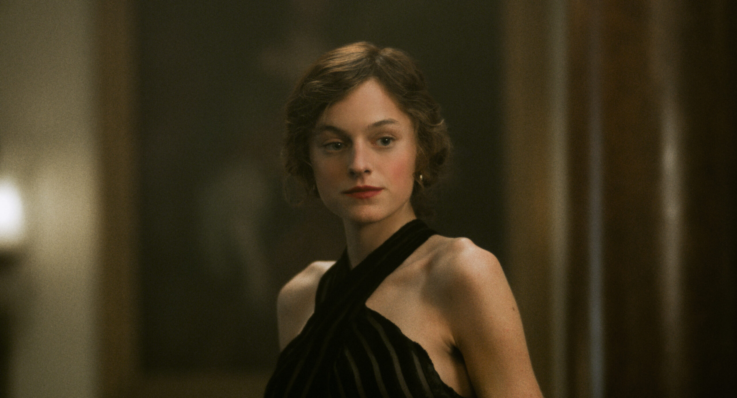 Connie looks down in a black dress in Lady Chatterley's Lover