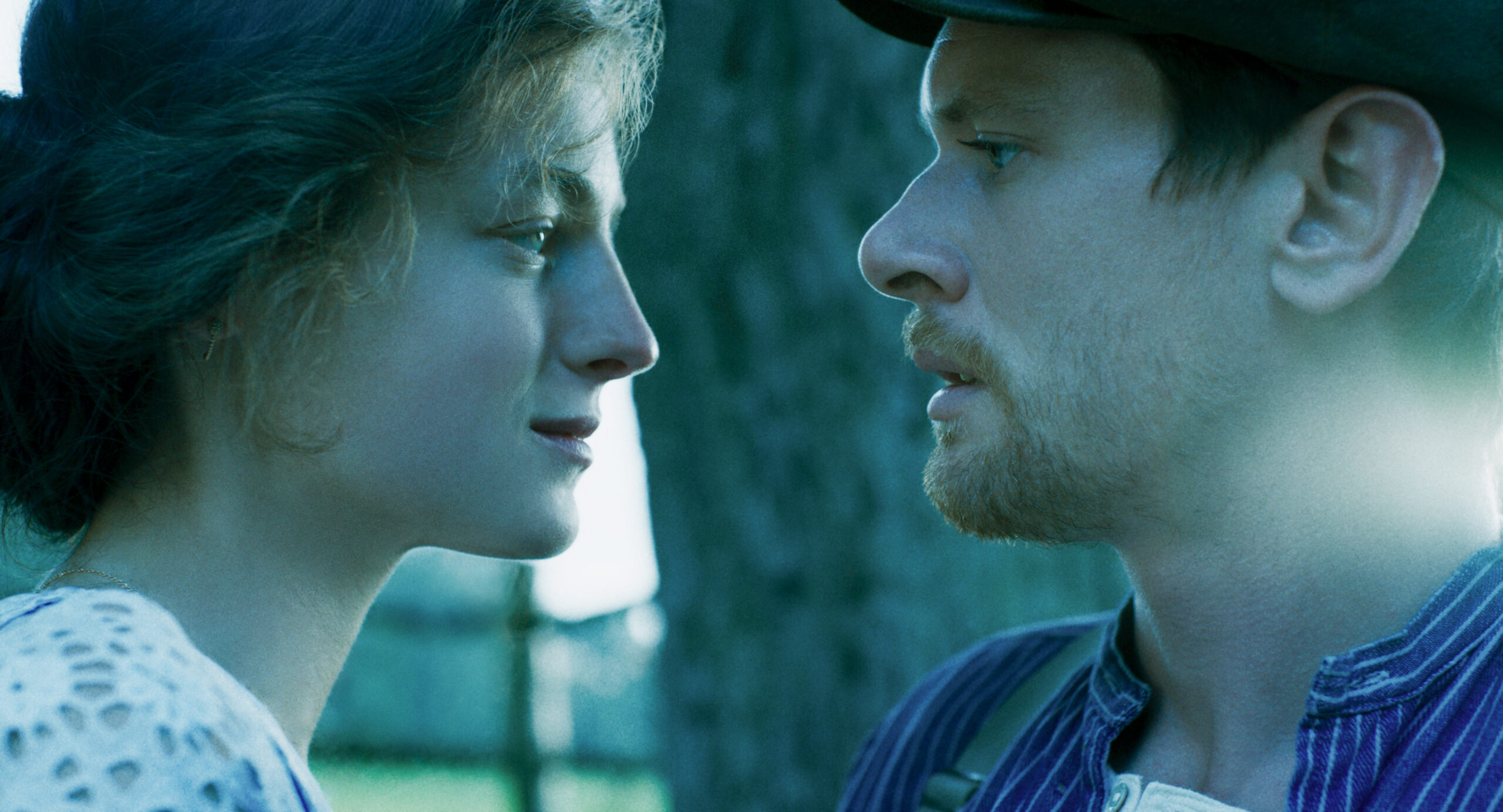 Connie and Oliver smile at each other in Lady Chatterley's Lover
