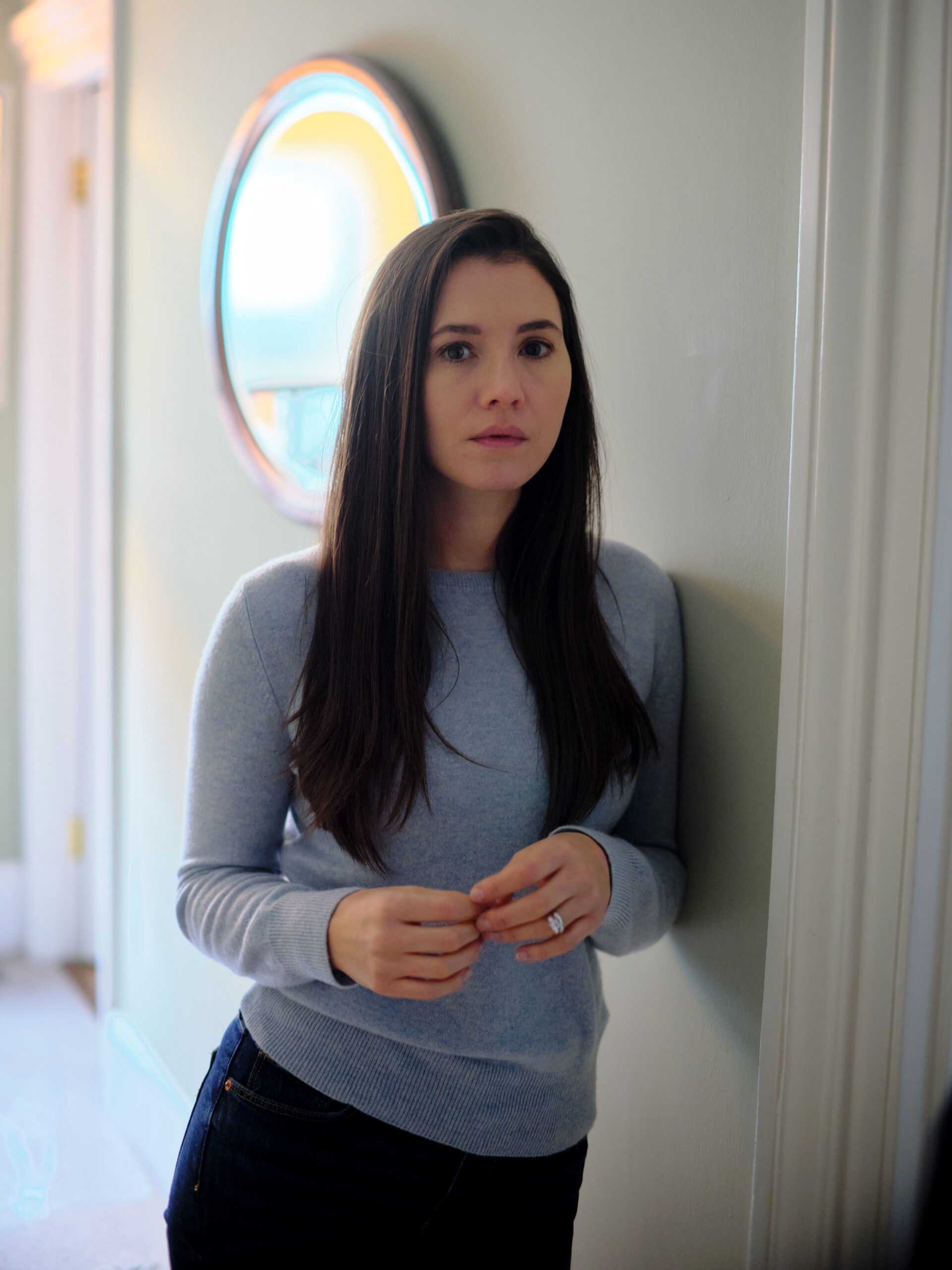 Simone leans on a wall in The Capture