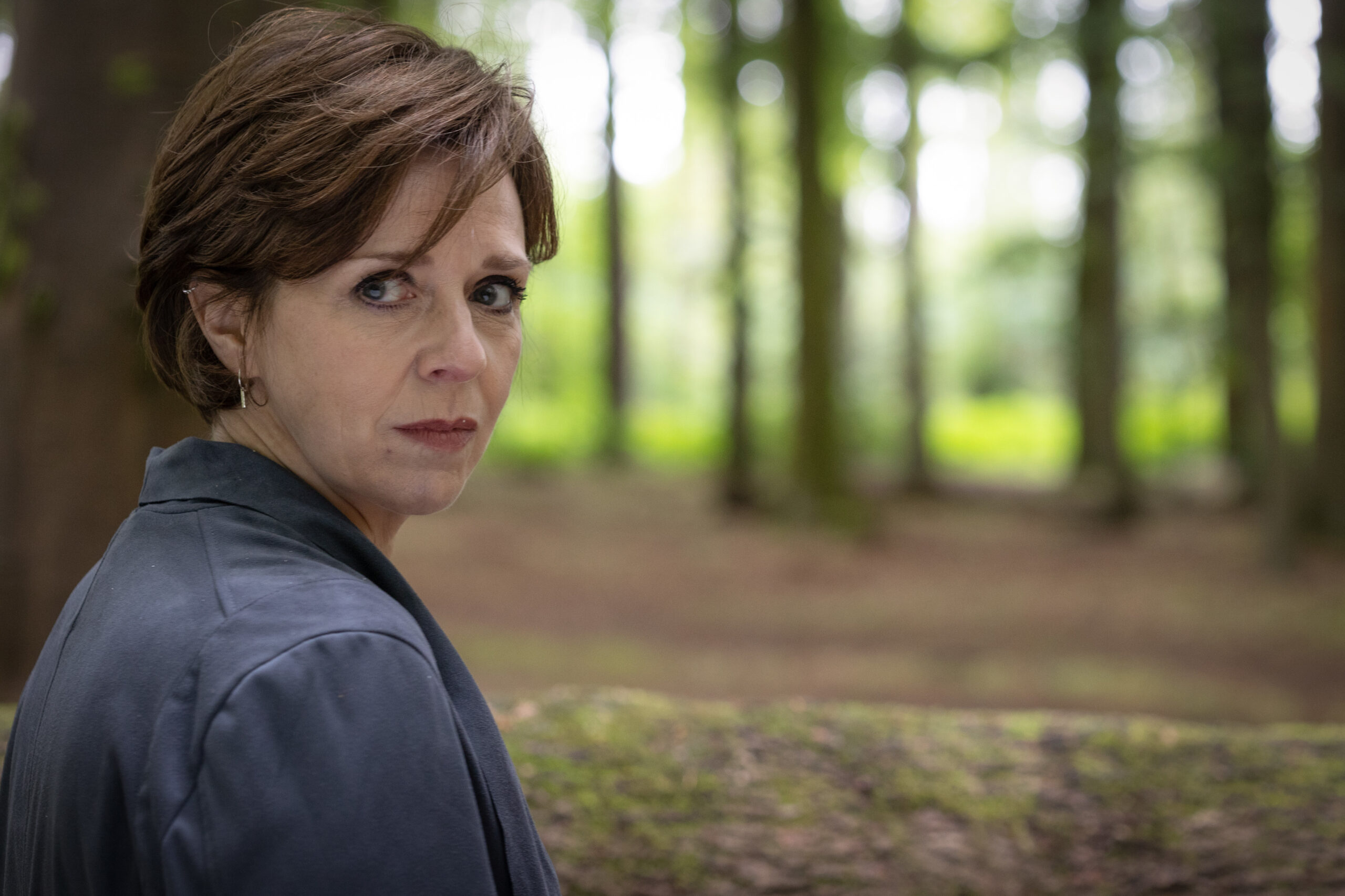 Isla Breck looks behind in the forest in Granite Harbour