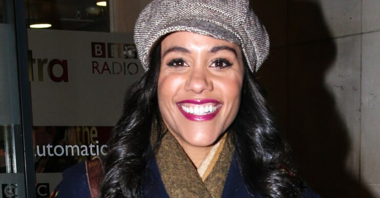 Alex Scott smiling and wearing a hat