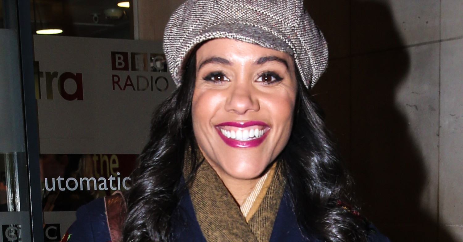 Alex Scott smiling and wearing a hat
