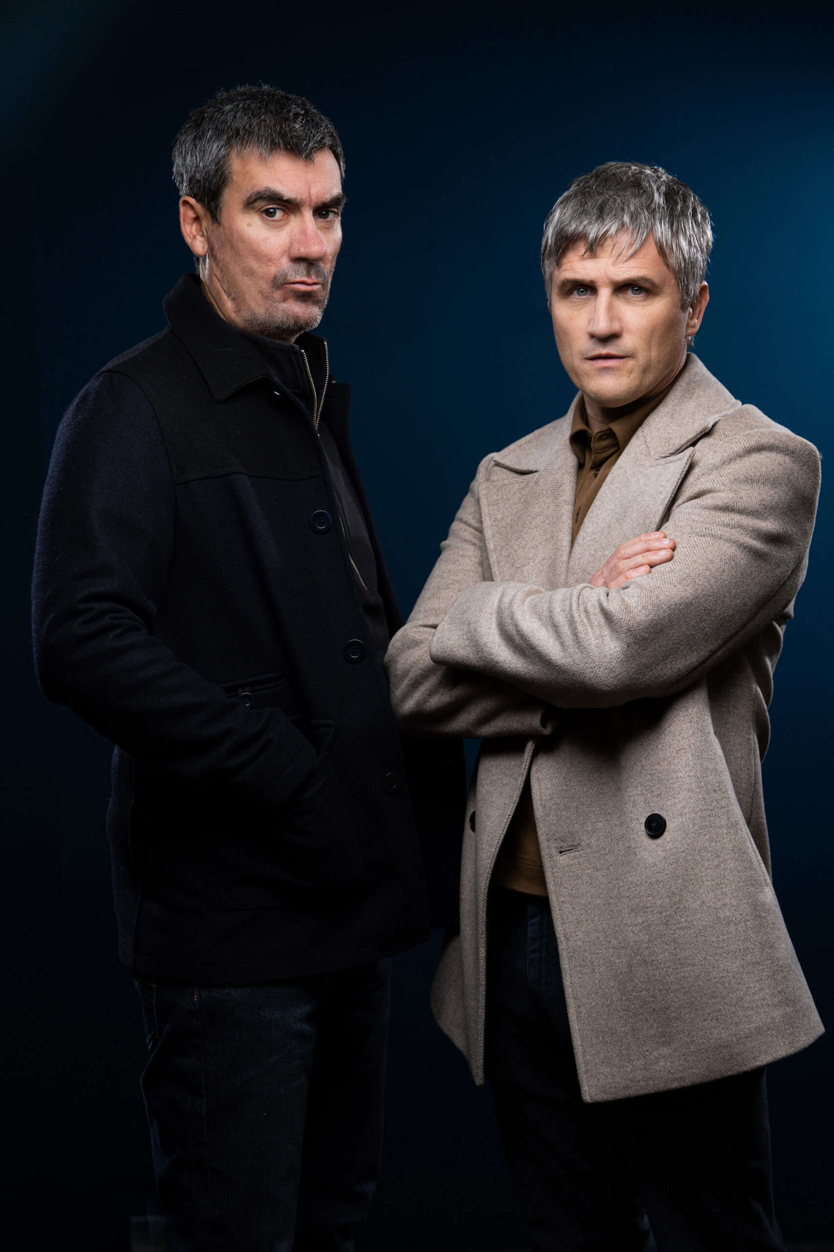 Emmerdale's Caleb and Cain are standing and Caleb has his arm crossed