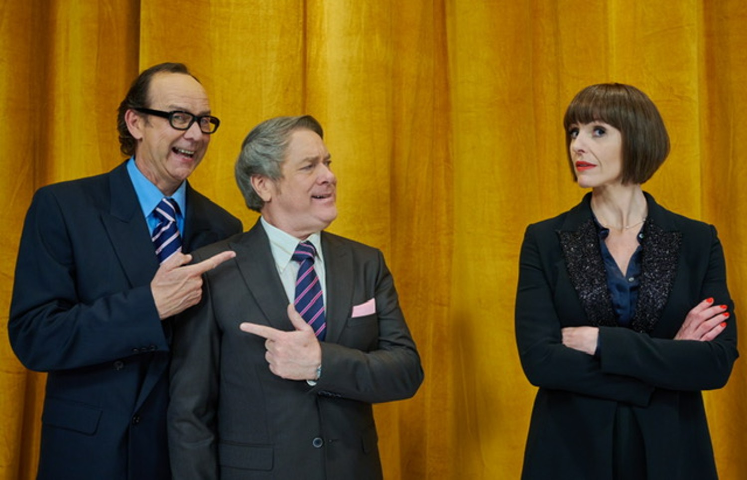 Jonty Stephens and Ian Ashpitel pointing at each other while Suranne Jones folds her arms in Christmas Carole