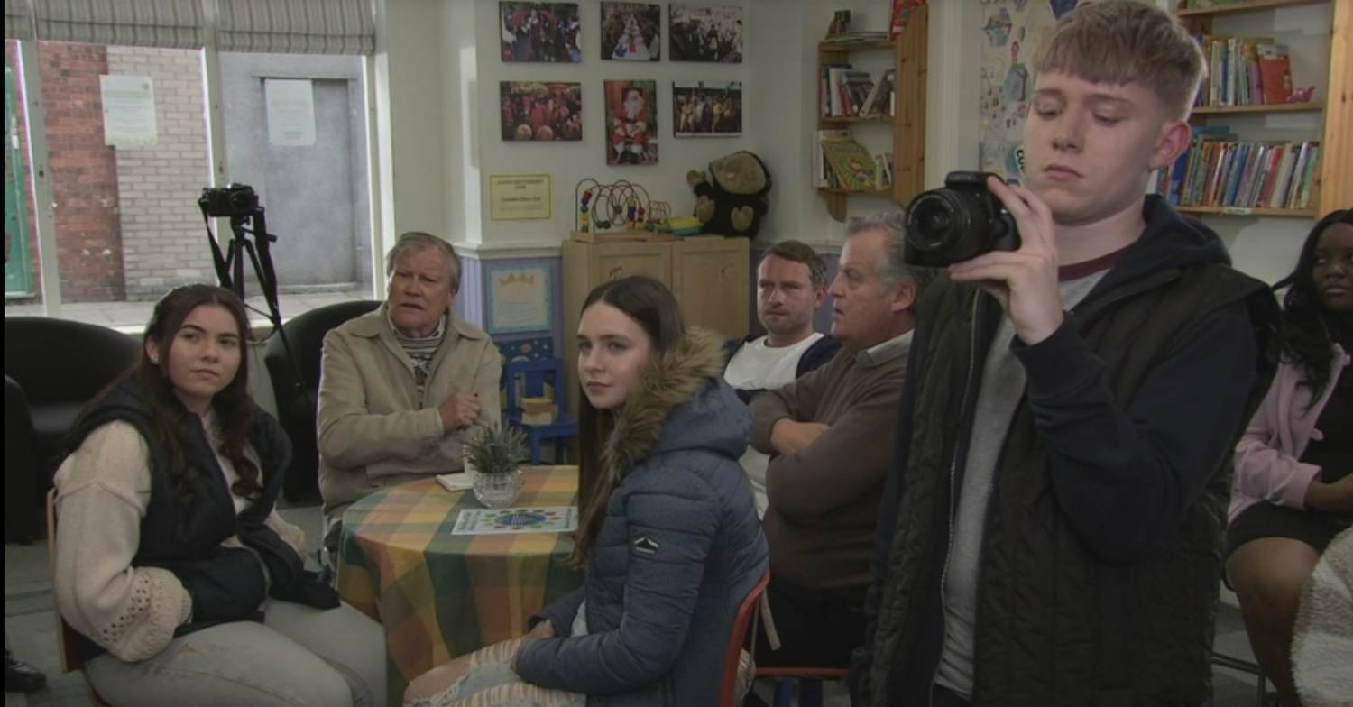 Coronation Street's Max is filming Griff's speech on a camera, amongst a crowd