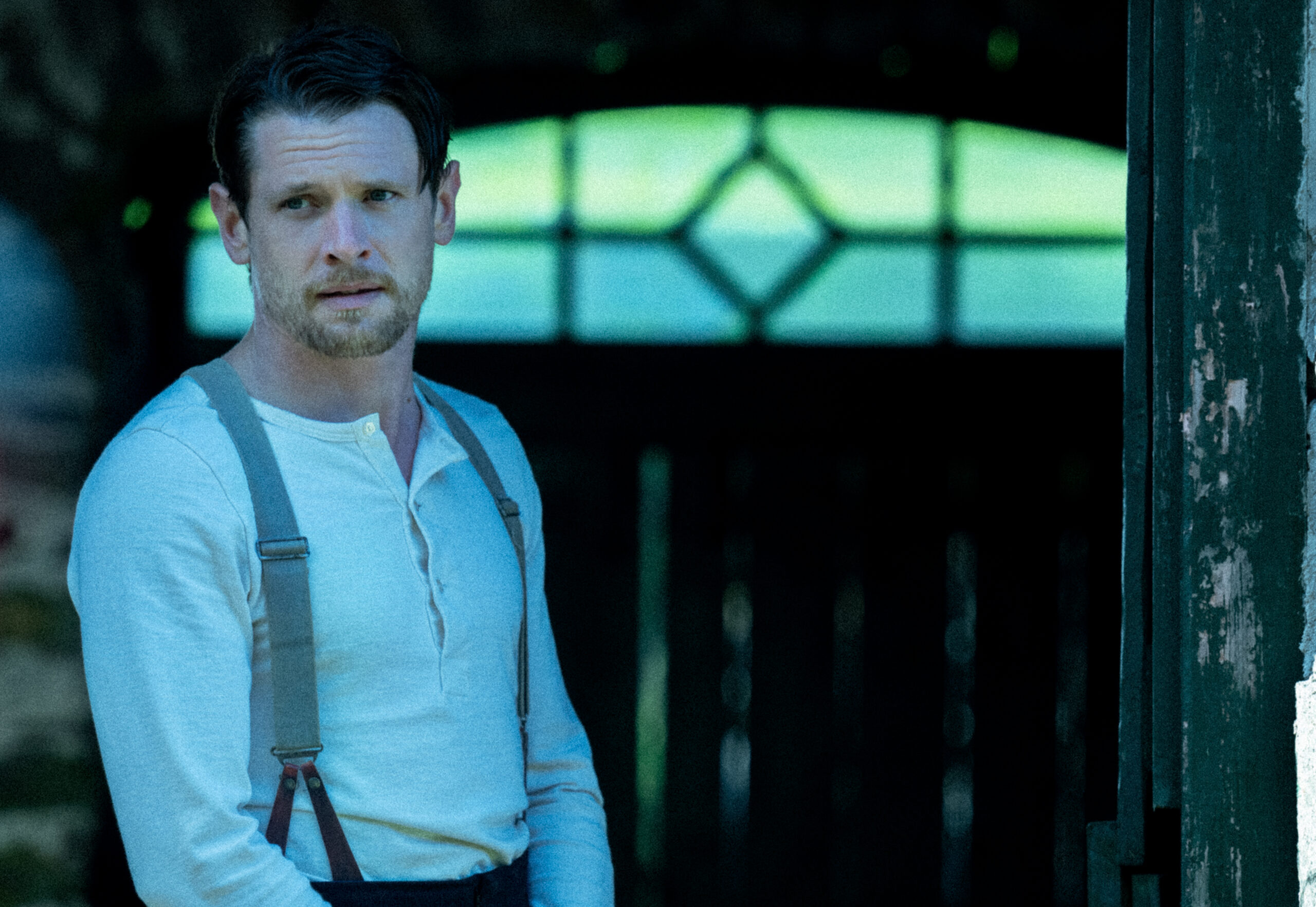 Oliver Mellors leans against a door in Lady Chatterley's Lover
