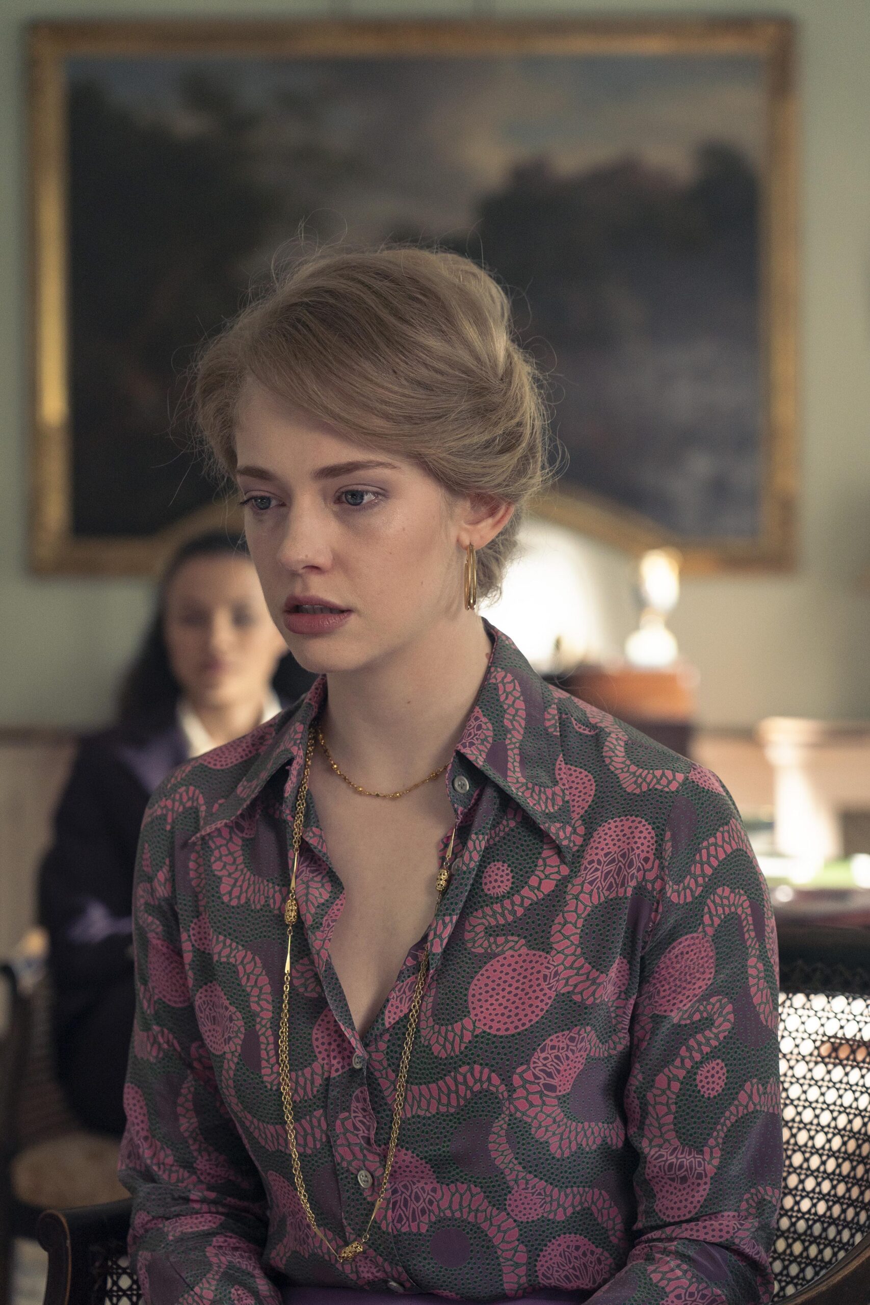 Lady Barbara looks down and upset in a large room