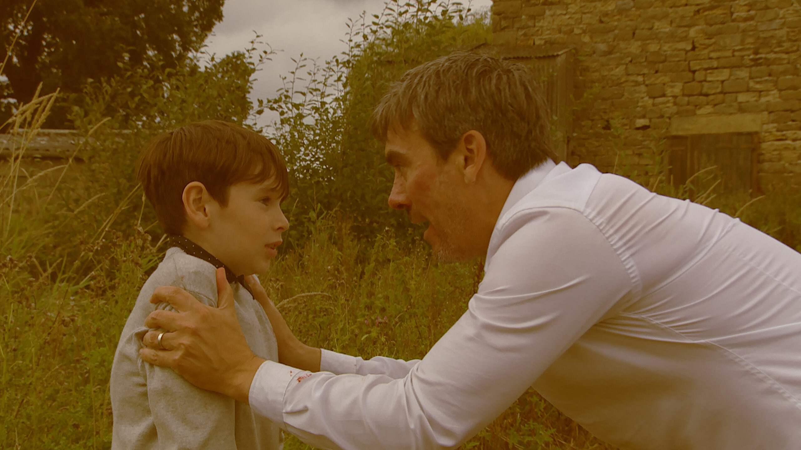 Cain talks to an upset Kyle outside in a sepia-toned flashback from Emmerdale