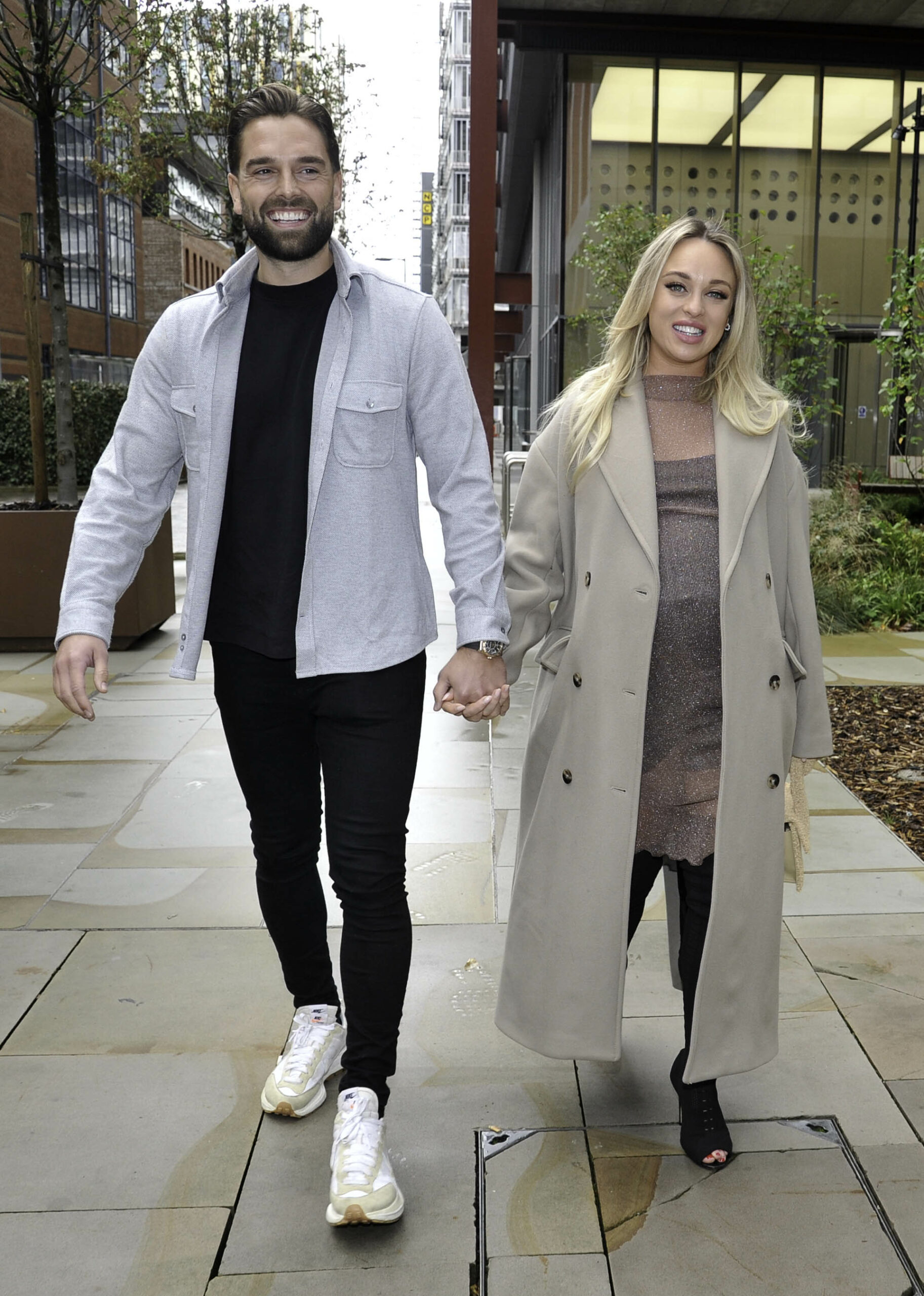Jorgie Porter and Ollie Piotrowski smiling as they hold hands