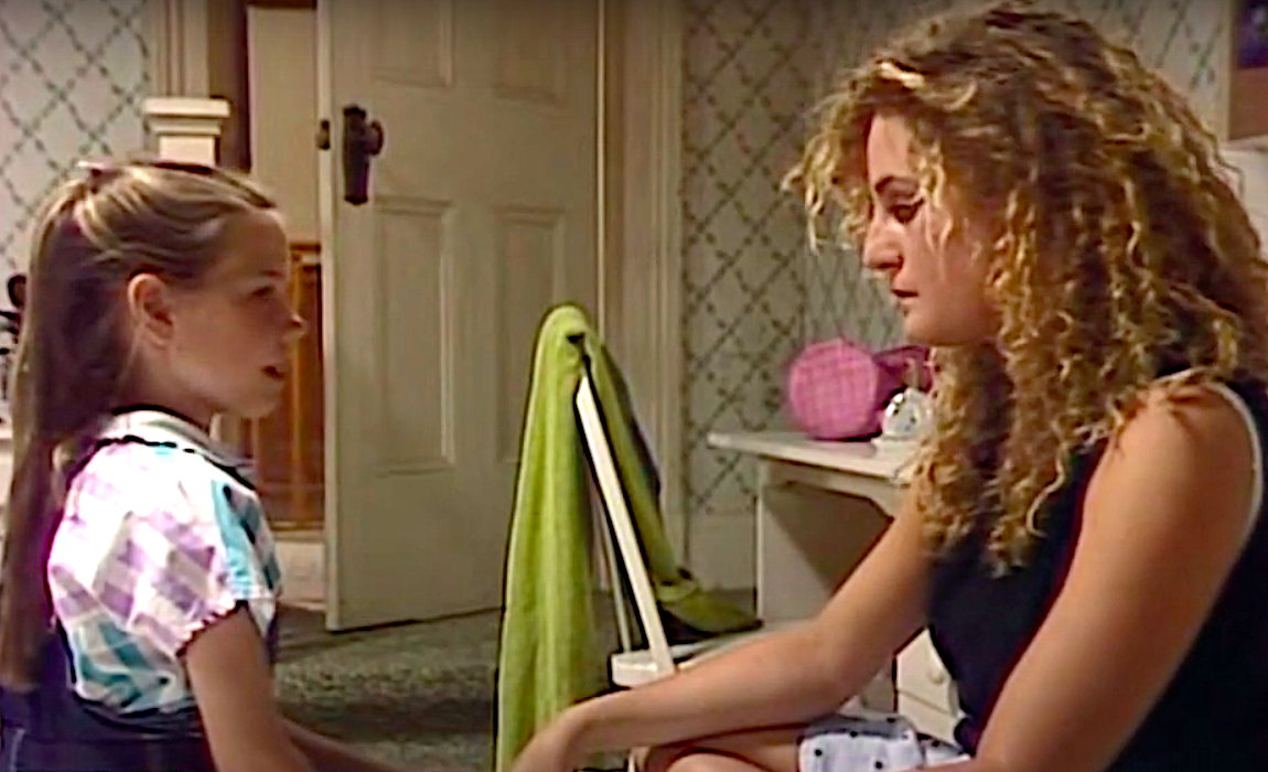 Sally and Carly chat on Carly's bed