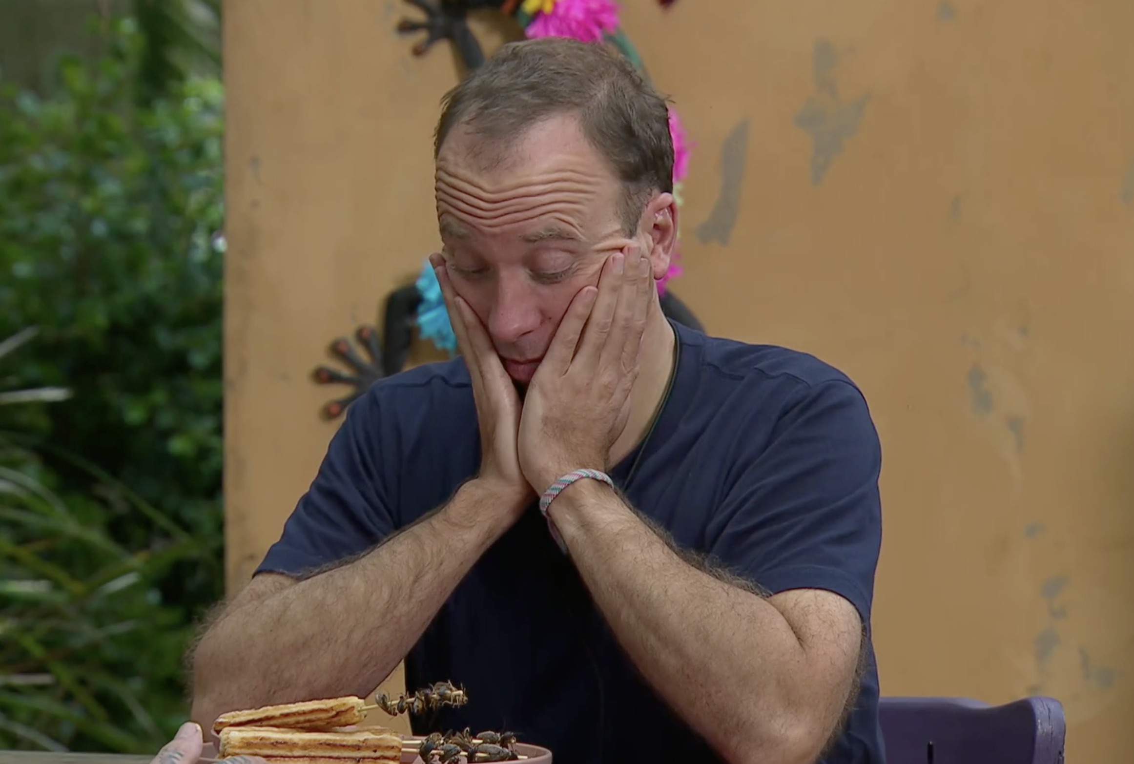 Matt Hancock hold his hands up to his face when he sees he has to eat cockroaches.