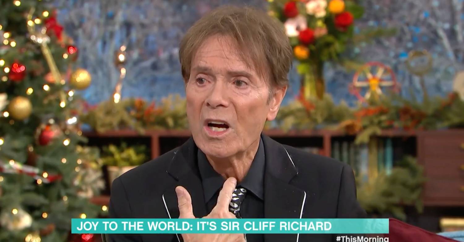Sir Cliff Richard points at his throat while speaking about health fears on This Morning