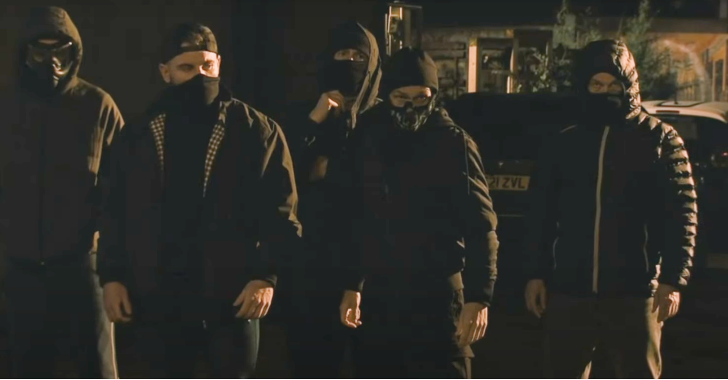 Five masked men standing in a line looking menacing in Coronation Street