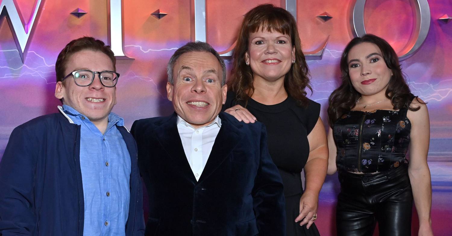 Warwick Davis smiles as his picture is taken alongside his family at Willow showing