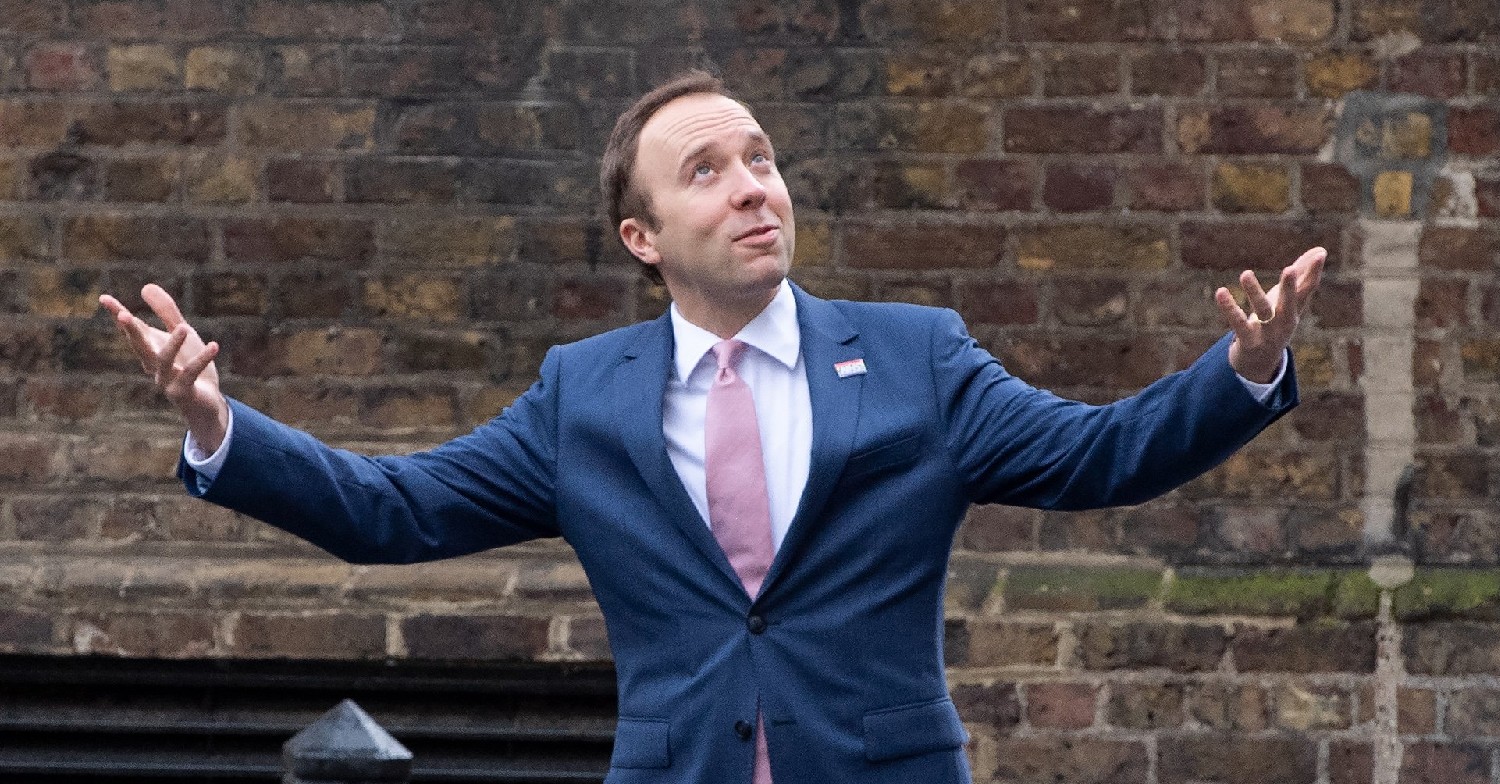 Matt Hancock with his arms open as he looks up