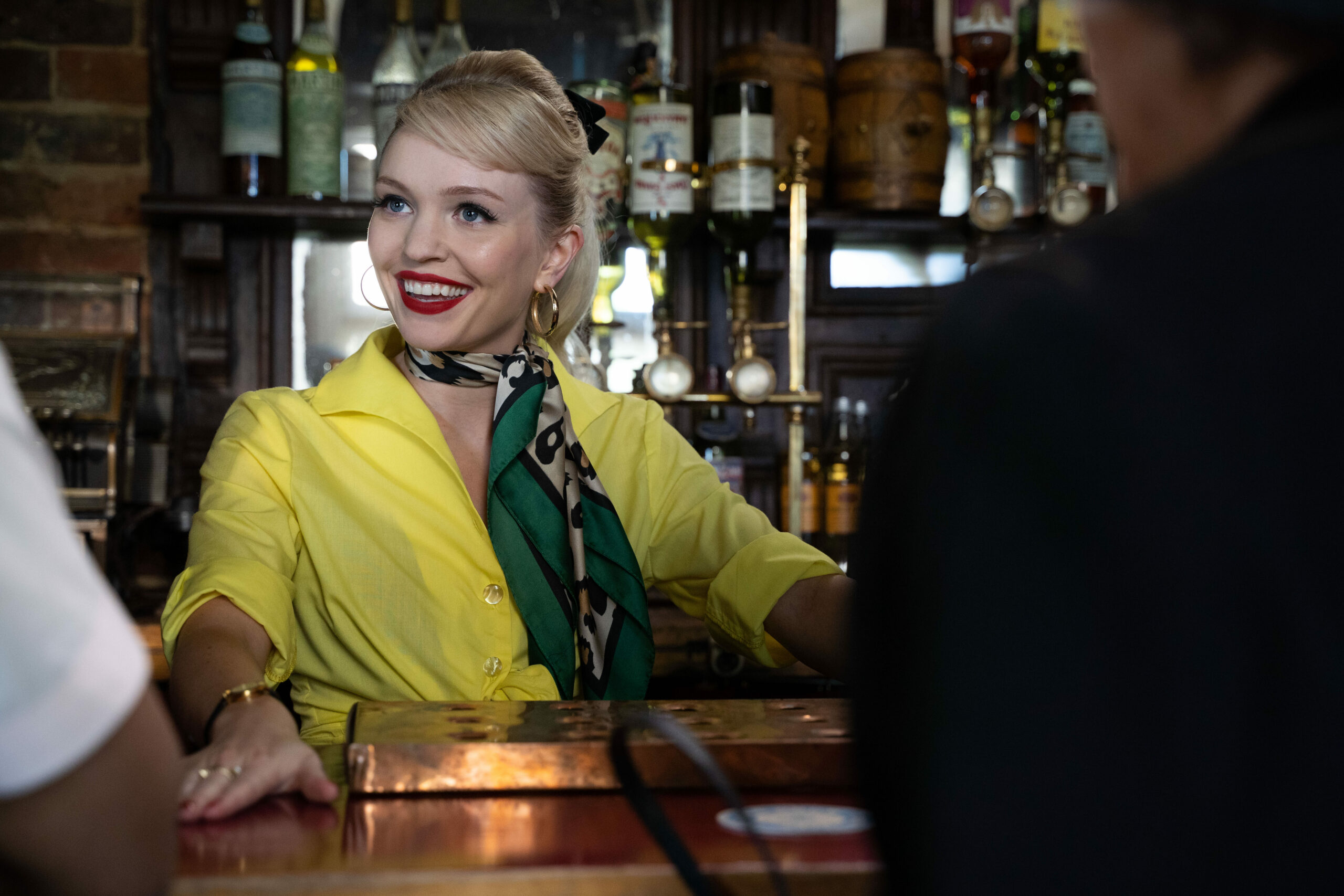 Natalie smiling behind the bar in The Larkins