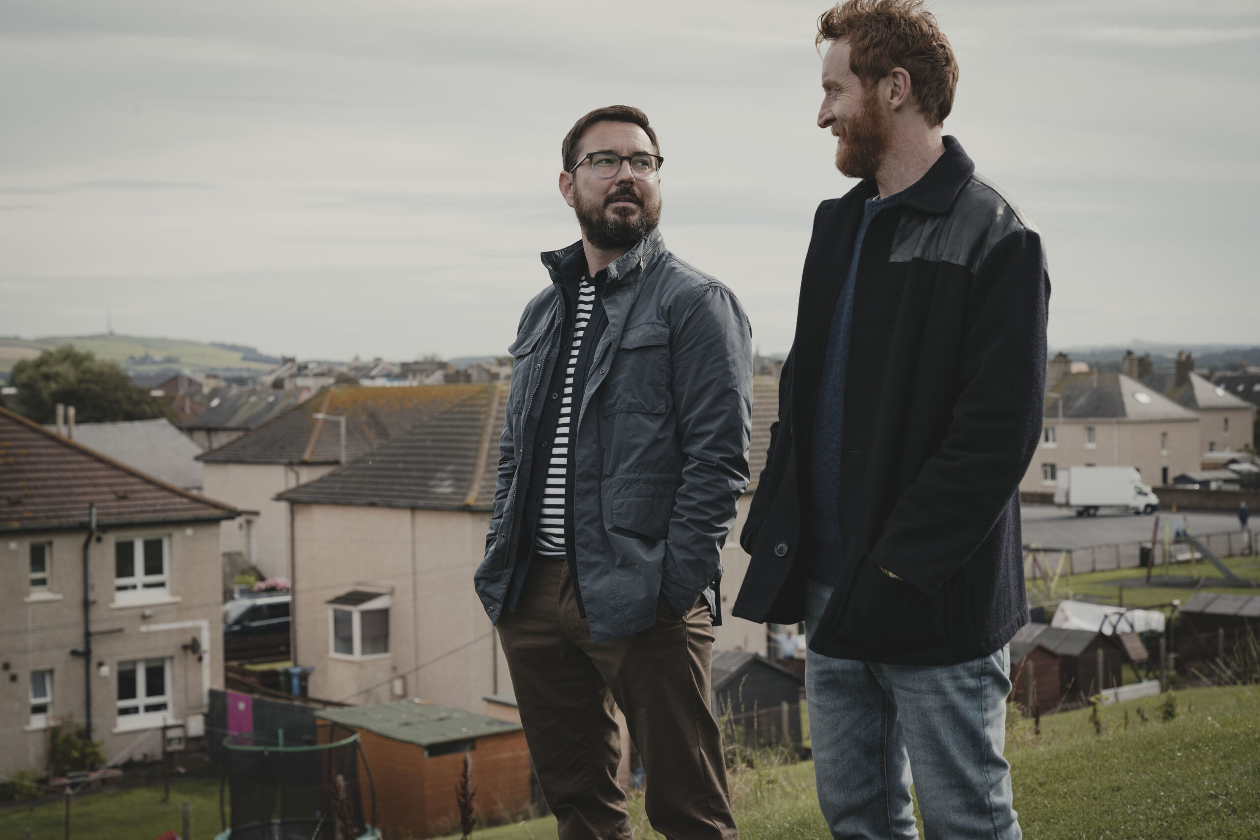 Jimmy and Tully stand on a hill in Mayflies