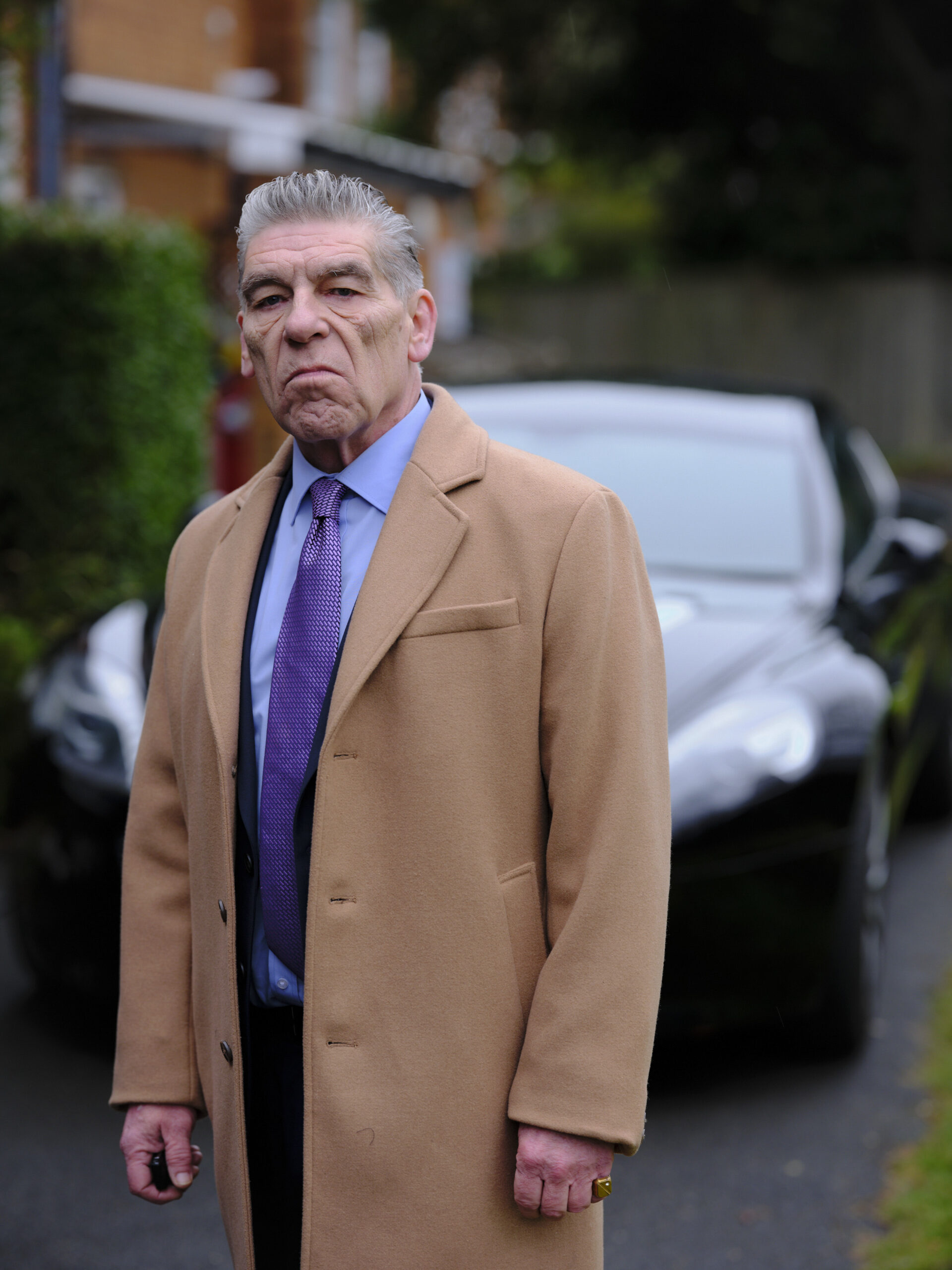 Luca Ricci stands next to his car in Strike Troubled Blood