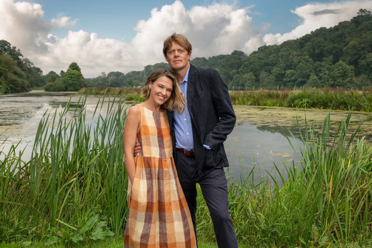 Martha and Humphrey pose by a lake in Beyond Paradise