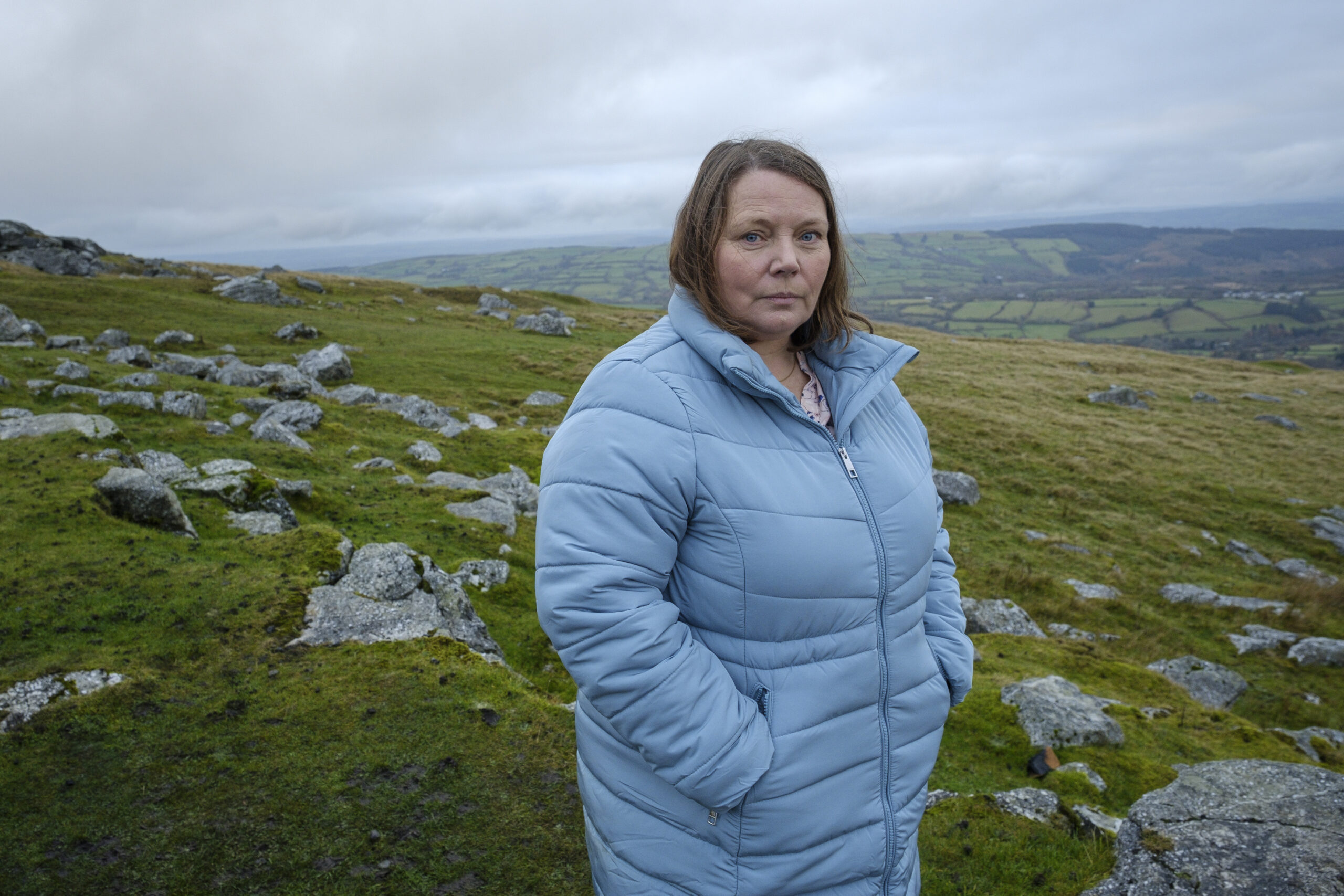 Sharon stands on a grassy hill in The Light In The Hall