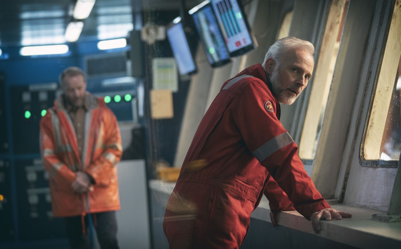 Alwyn (Mark Bonnar) leans over a wall on The Rig