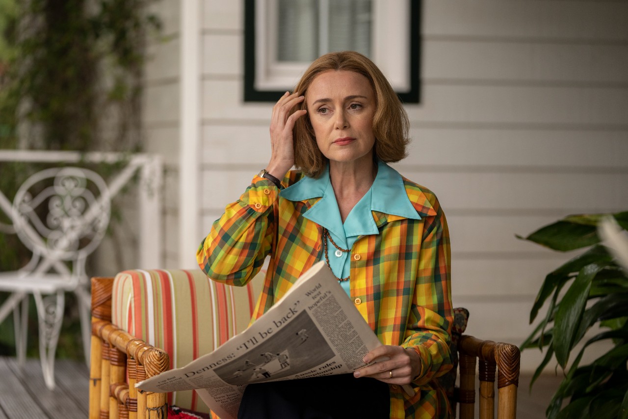 Barbara Stonehouse reads a newspaper on a chair
