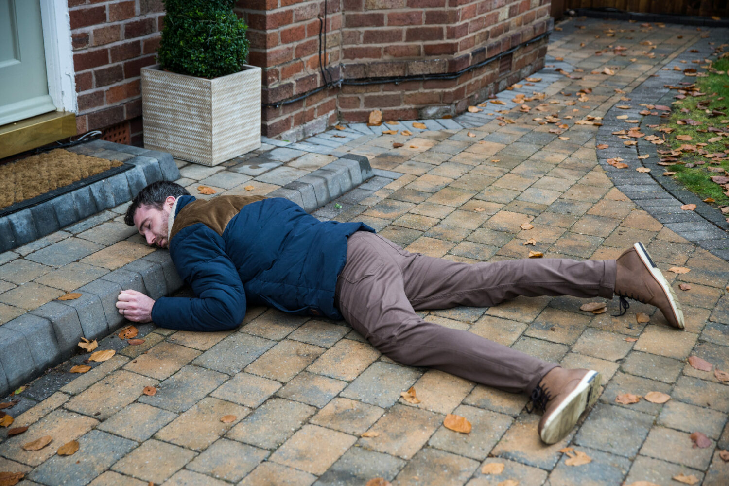 Coronation Street's Mike is lying on the floor, unconscious, outside of his house