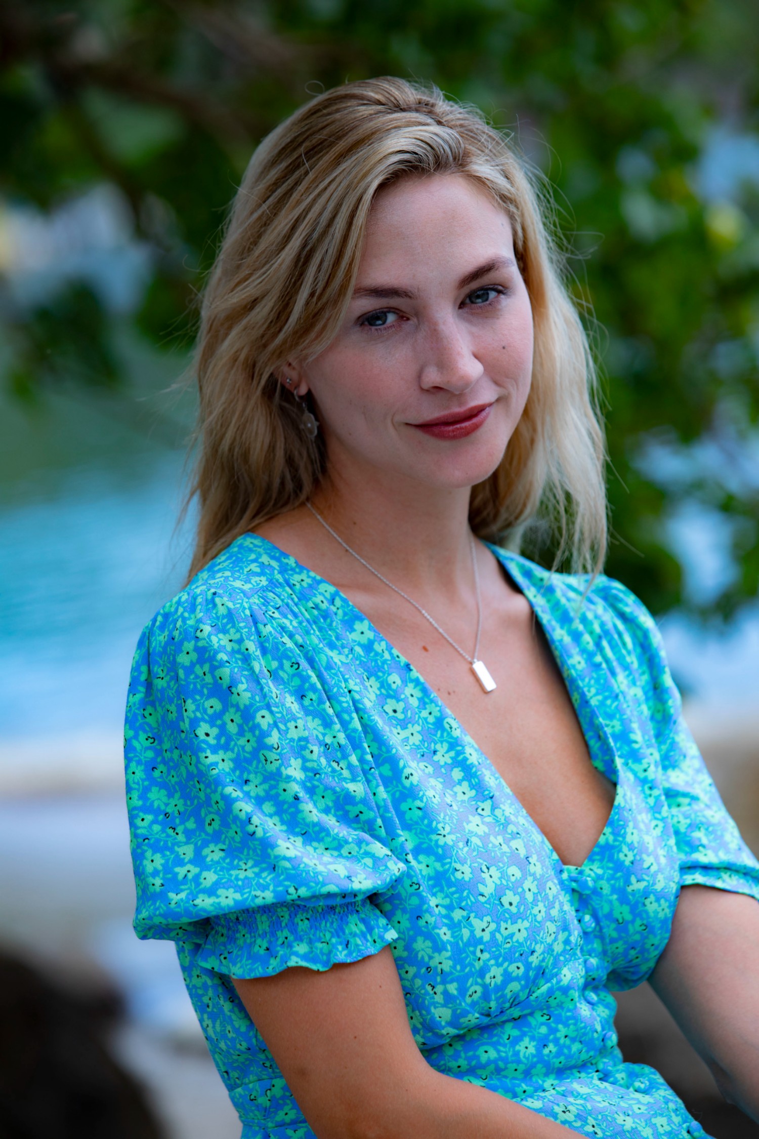 Death in Paradise star Chelsea Edge posing in a blue dress